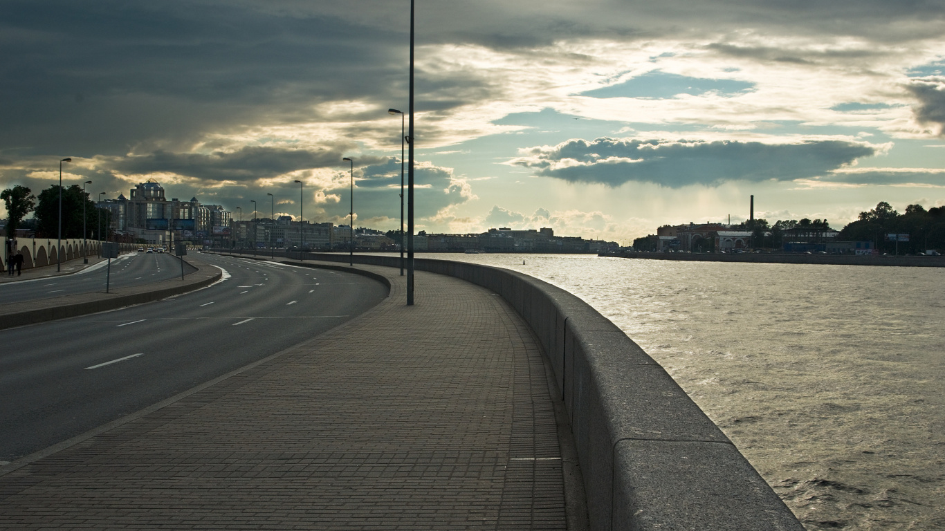 Gray Concrete Road Near Body of Water Under Cloudy Sky During Daytime. Wallpaper in 1366x768 Resolution