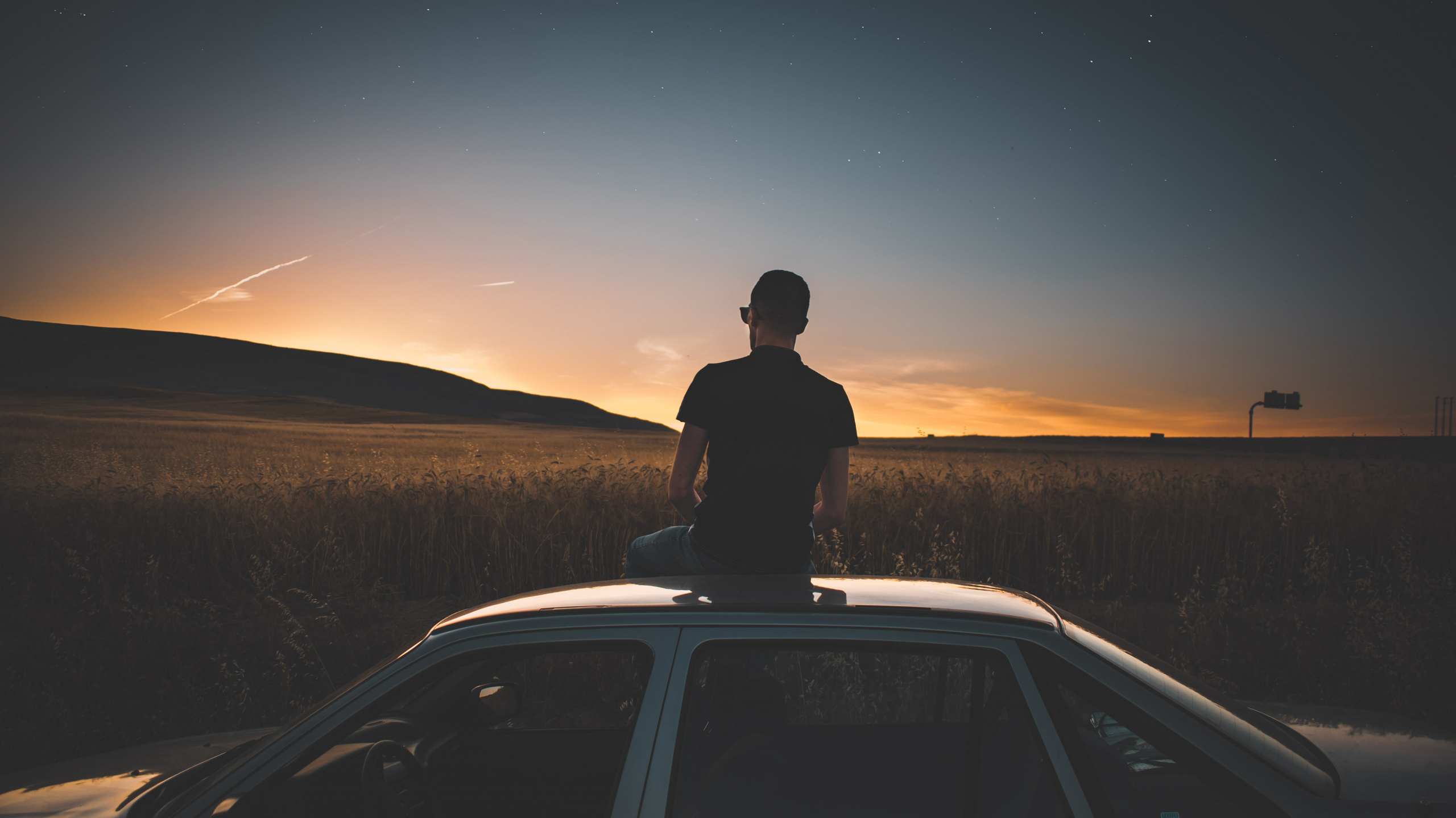 Silhouette of Man Standing on Car During Night Time. Wallpaper in 2560x1440 Resolution