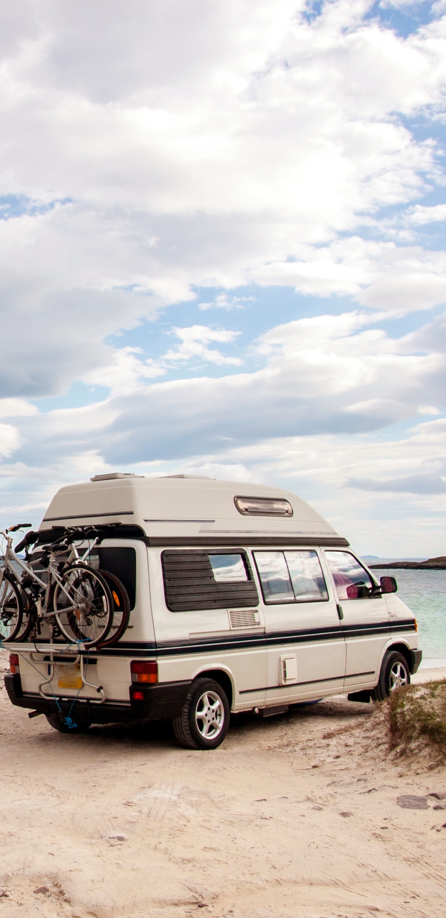 White and Black Van on Brown Sand Near Body of Water During Daytime. Wallpaper in 1440x2960 Resolution