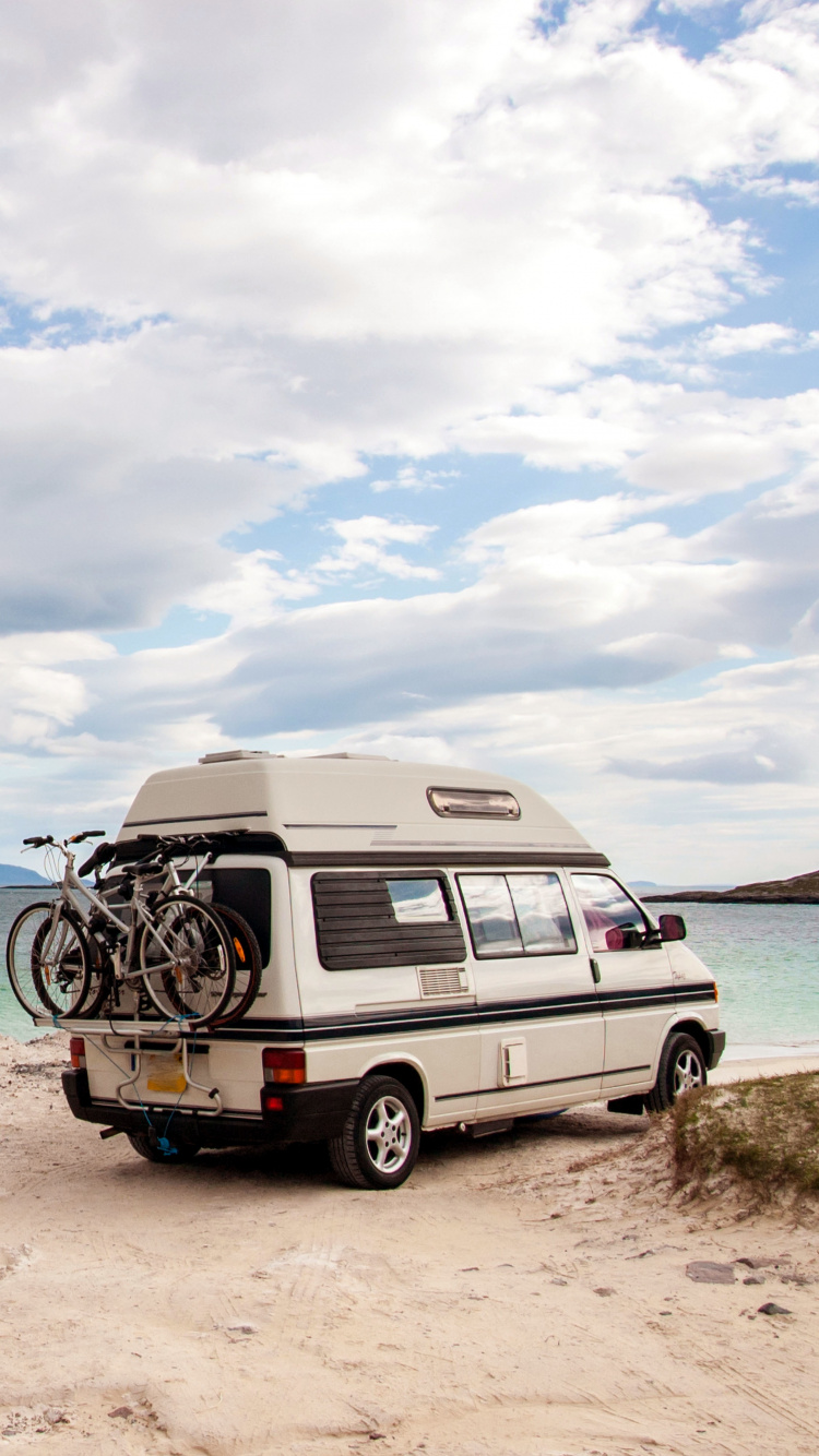 White and Black Van on Brown Sand Near Body of Water During Daytime. Wallpaper in 750x1334 Resolution