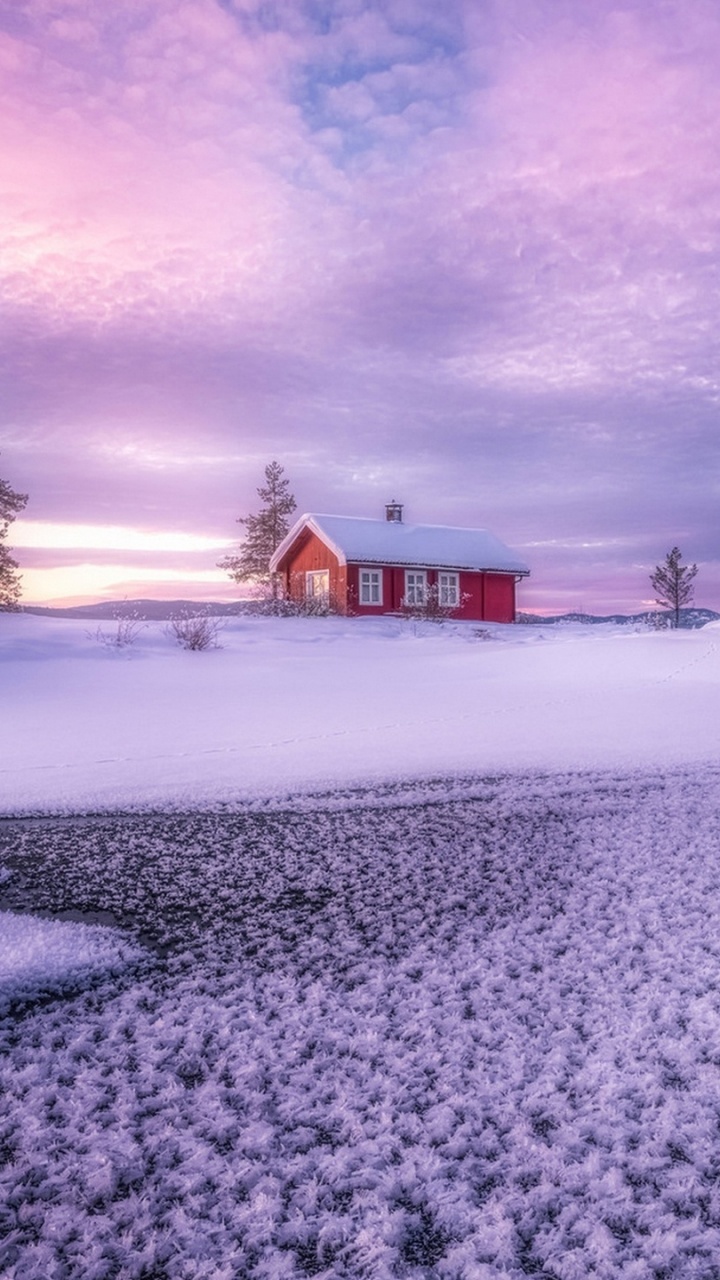 Braunes Holzhaus Auf Schneebedecktem Boden Unter Grauen Wolken. Wallpaper in 720x1280 Resolution