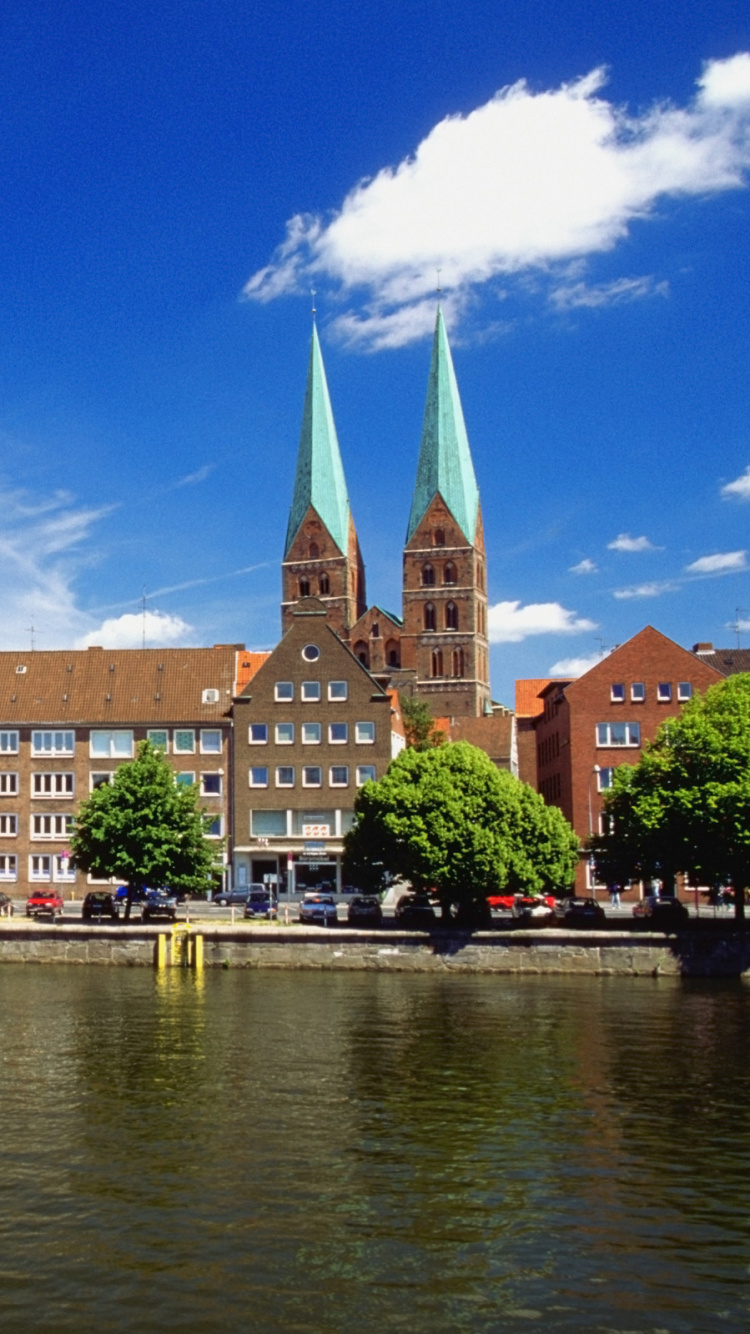 Brown Concrete Building Near Body of Water Under Blue Sky During Daytime. Wallpaper in 750x1334 Resolution