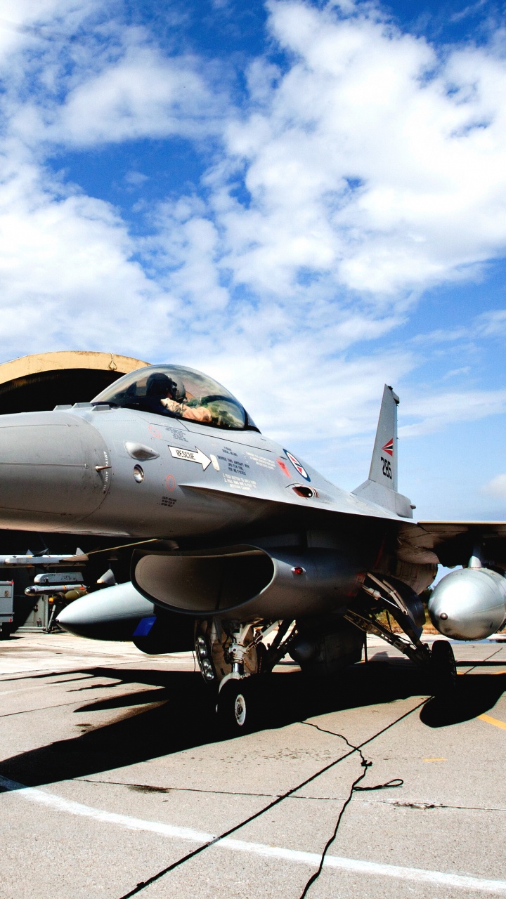 Grauer Kampfjet Auf Grauem Betonboden Unter Blauem Und Weißem Sonnigem Bewölktem Himmel Tagsüber. Wallpaper in 720x1280 Resolution