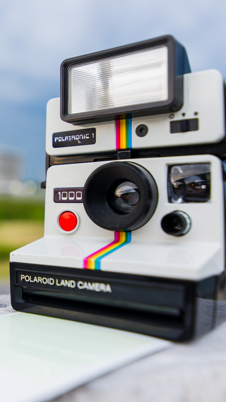 Cámara Polaroid en Blanco y Negro Sobre Mesa Blanca. Wallpaper in 750x1334 Resolution