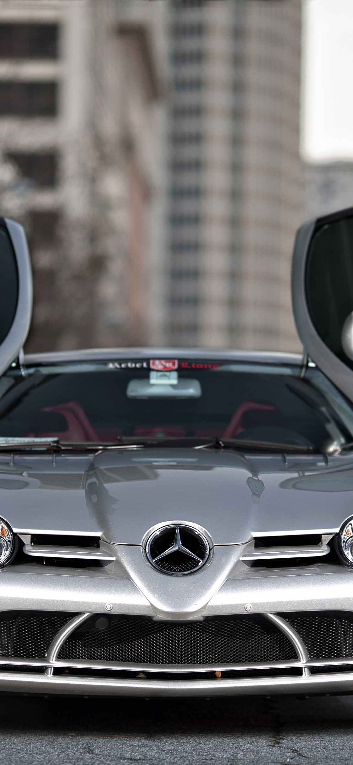 Silver Mercedes Benz Car in Front of Brown Brick Building. Wallpaper in 1125x2436 Resolution