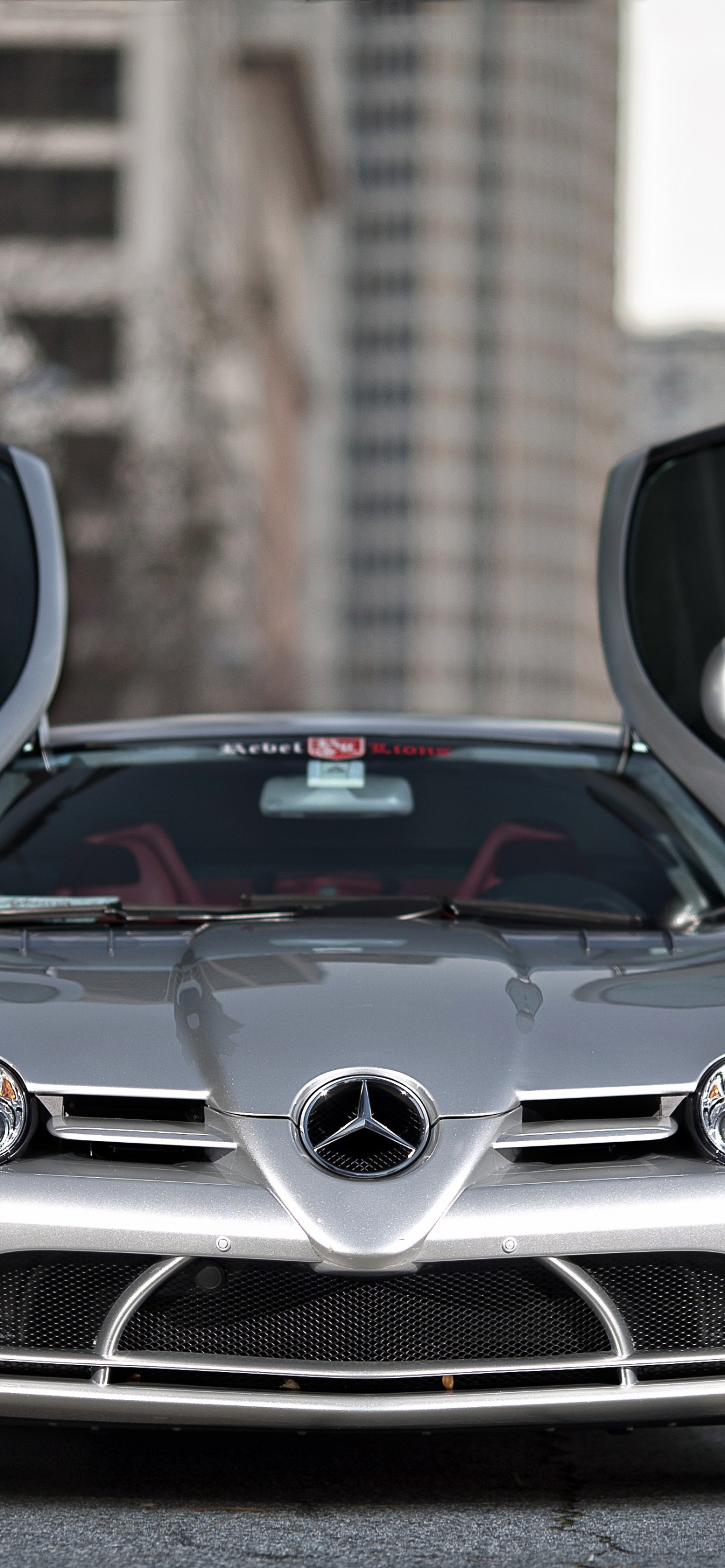Silver Mercedes Benz Car in Front of Brown Brick Building. Wallpaper in 1242x2688 Resolution