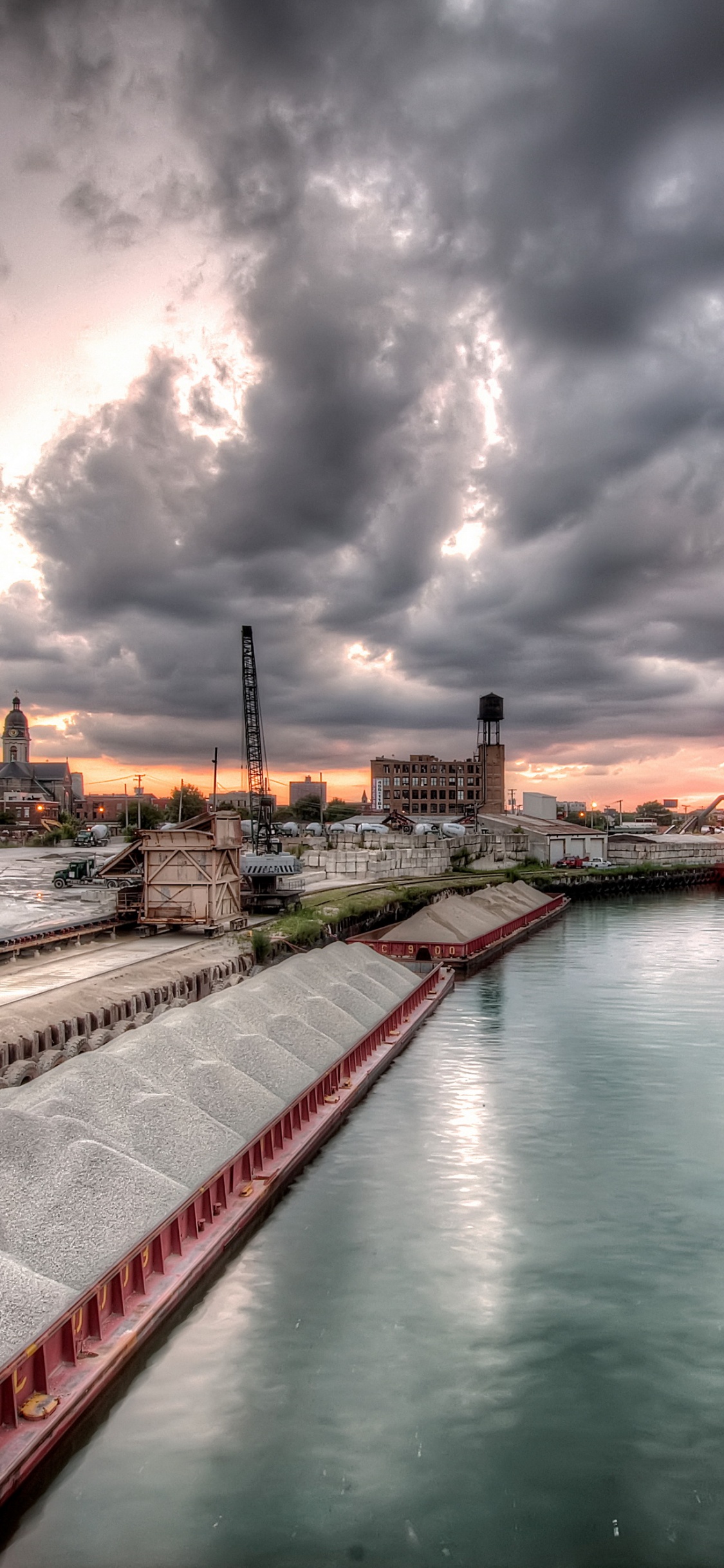 Body of Water Near Buildings Under Cloudy Sky During Daytime. Wallpaper in 1125x2436 Resolution