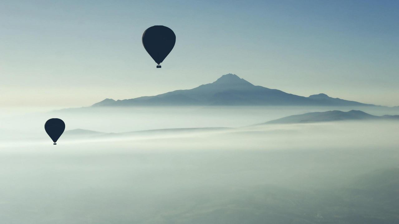 Globo Aerostático Azul Volando Sobre Las Montañas Durante el Día. Wallpaper in 1280x720 Resolution