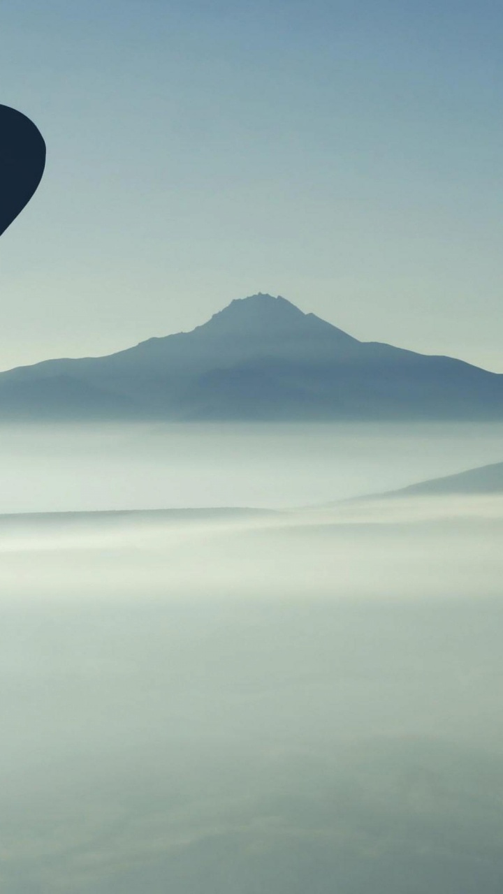 Blue Hot Air Balloon Flying Over The Mountains During Daytime. Wallpaper in 720x1280 Resolution