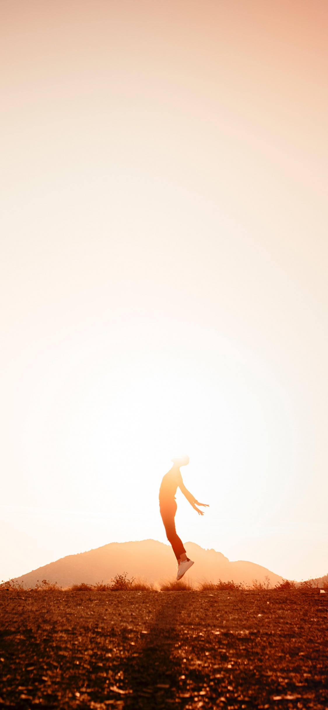 Person, Die Tagsüber Auf Braunem Felsen Steht. Wallpaper in 1125x2436 Resolution