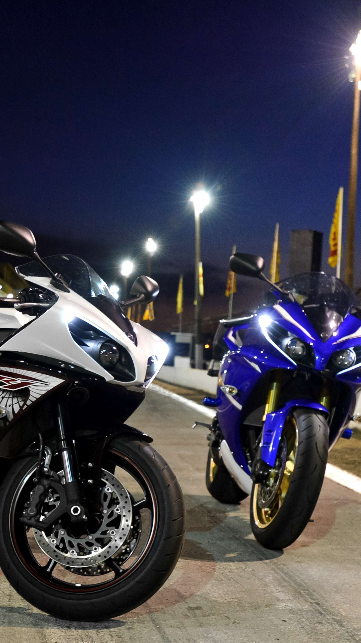 Schwarzes Und Weißes Sportfahrrad, Das Nachts Neben Dem Gelben Und Weißen Bus Geparkt Ist. Wallpaper in 1440x2560 Resolution