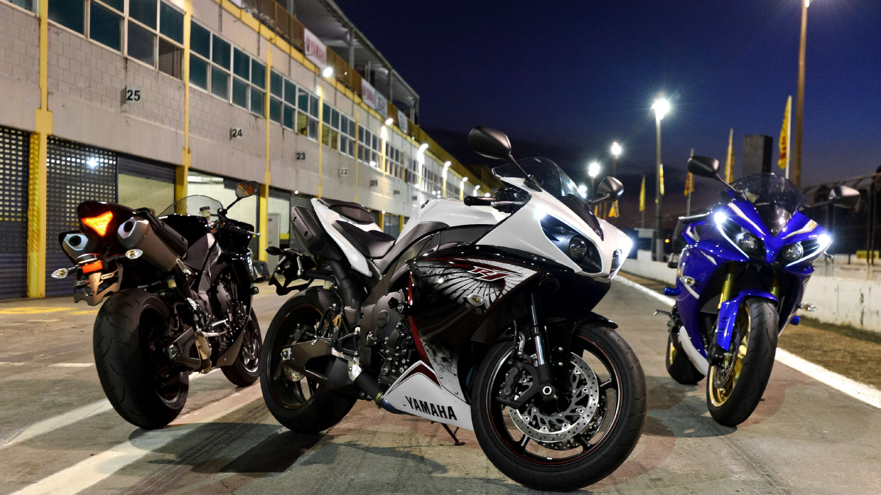 Black and White Sports Bike Parked Beside Yellow and White Bus During Night Time. Wallpaper in 1280x720 Resolution