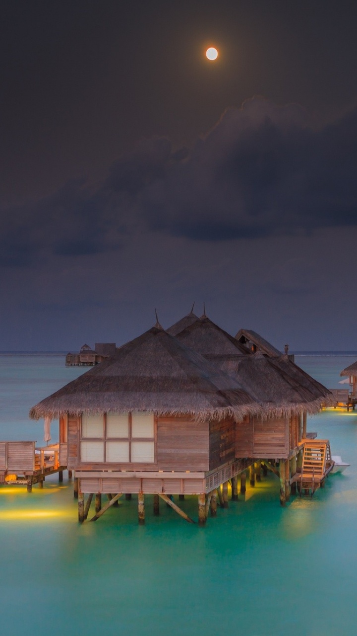 Brown Wooden House on Body of Water During Night Time. Wallpaper in 720x1280 Resolution