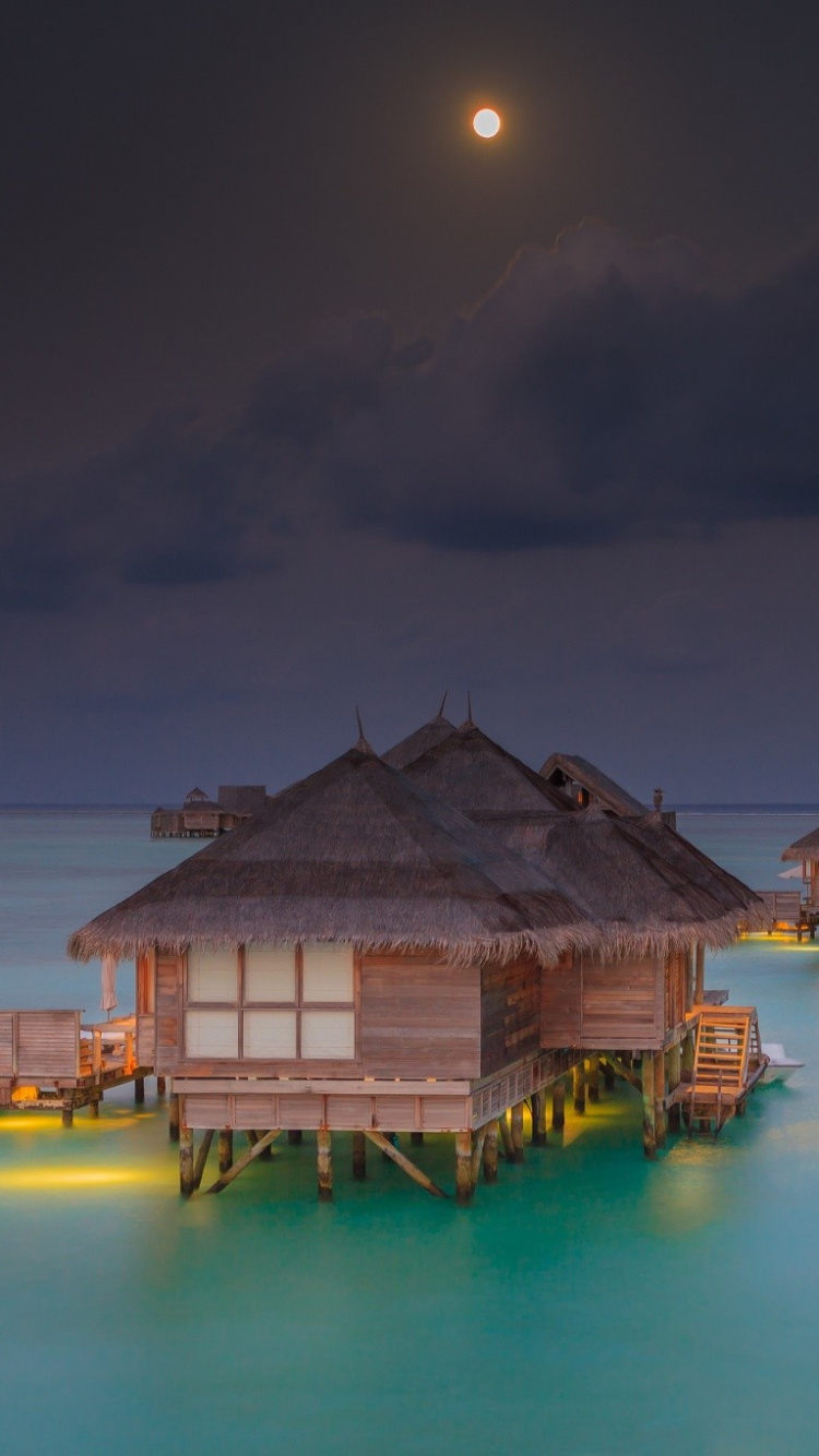 Brown Wooden House on Body of Water During Night Time. Wallpaper in 750x1334 Resolution