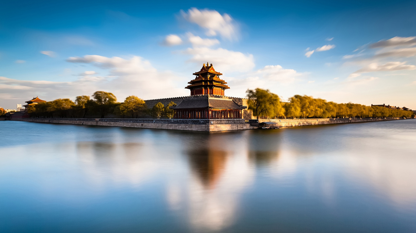 Brown Concrete Building Near Body of Water Under Blue Sky During Daytime. Wallpaper in 1366x768 Resolution