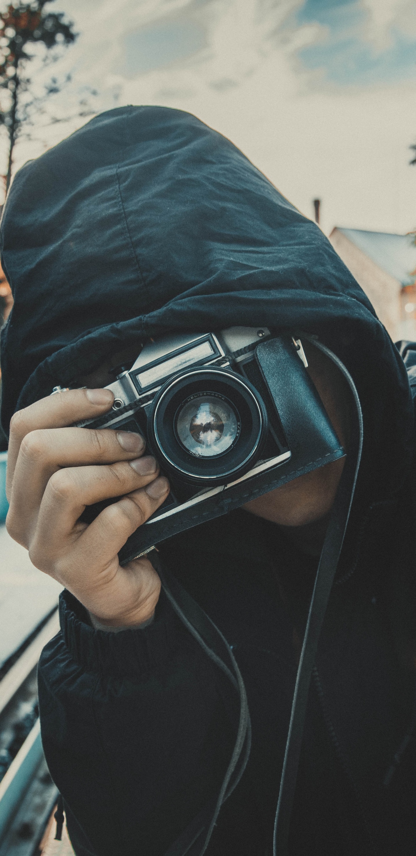 Man in Black Hoodie Holding Black Camera. Wallpaper in 1440x2960 Resolution