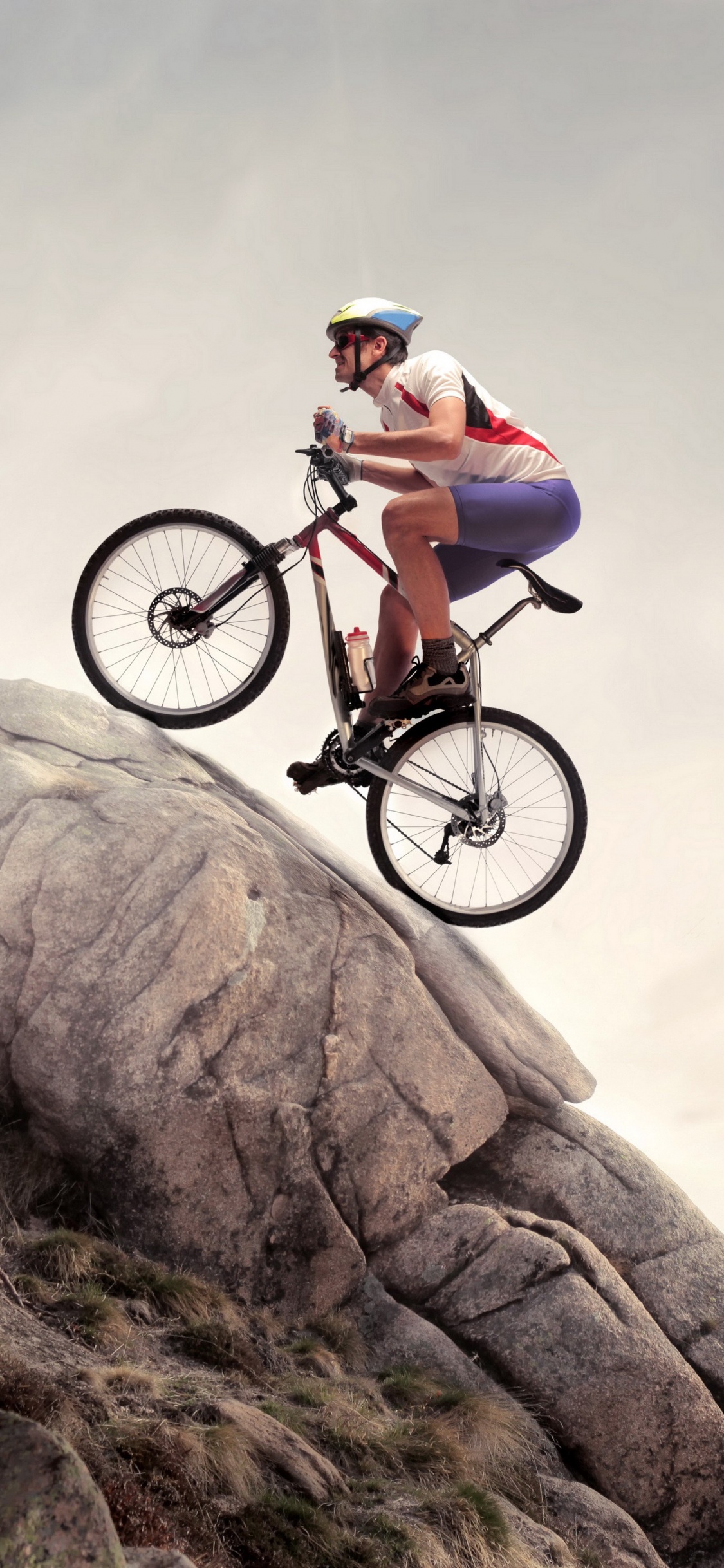 Mann im Grünen Hemd, Der Tagsüber Auf Einem Schwarzen Mountainbike Auf Einem Braunen Felsigen Berg Fährt. Wallpaper in 1125x2436 Resolution