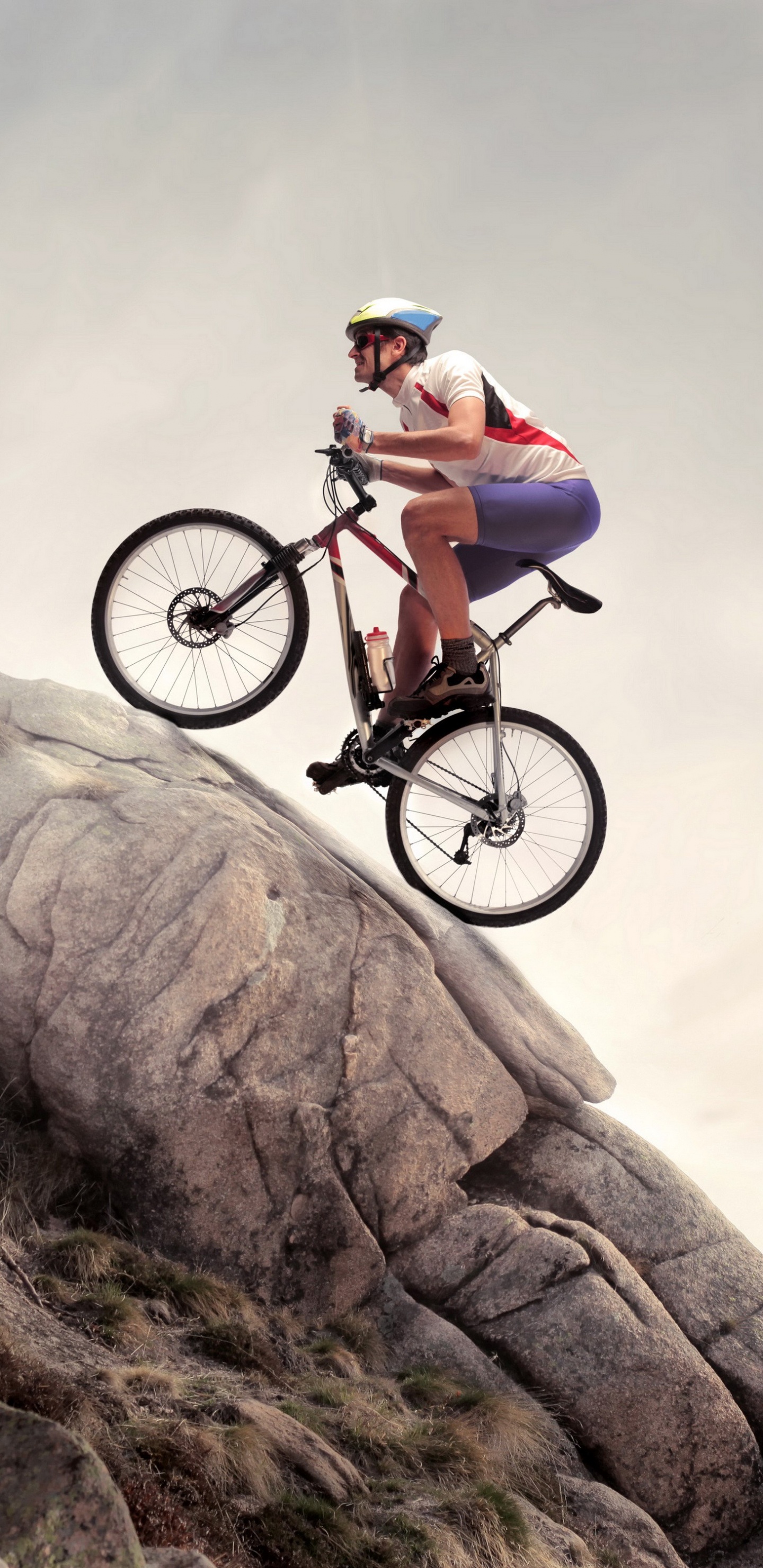 Man in Green Shirt Riding on Black Mountain Bike on Brown Rocky Mountain During Daytime. Wallpaper in 1440x2960 Resolution