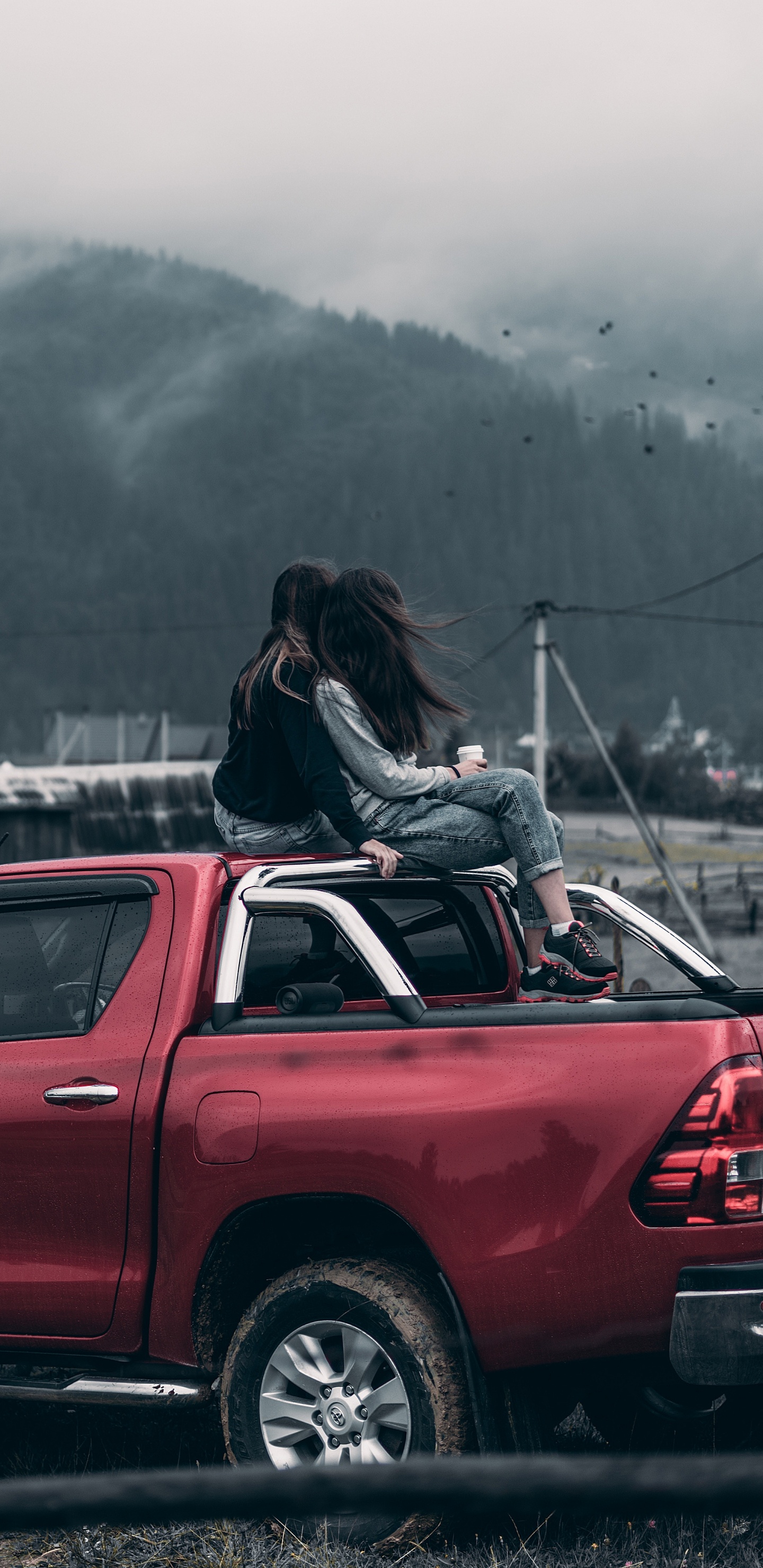 Mujer de Chaqueta Negra Sentada en el Capó Del Coche Rojo Durante el Día. Wallpaper in 1440x2960 Resolution