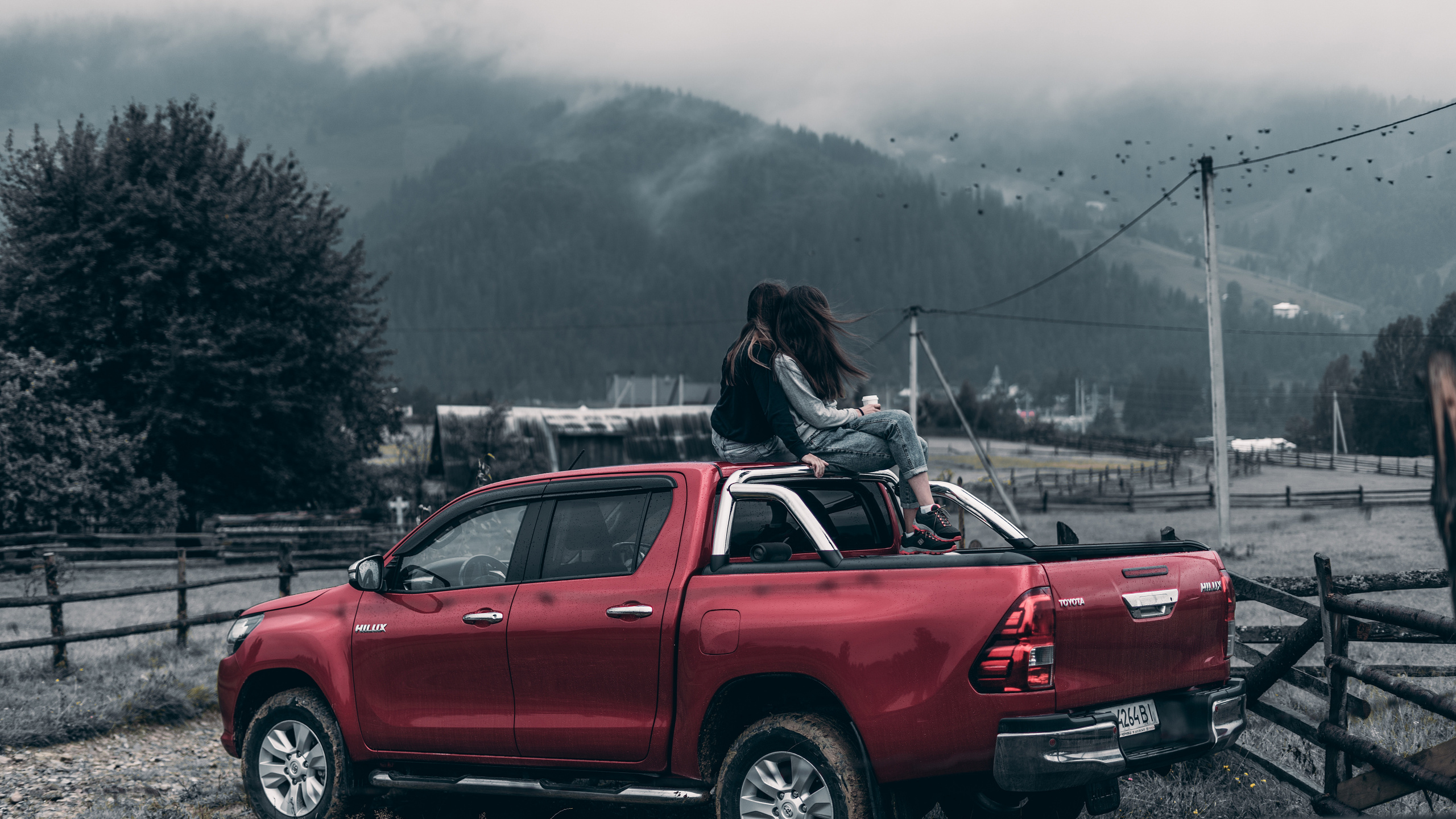 Mujer de Chaqueta Negra Sentada en el Capó Del Coche Rojo Durante el Día. Wallpaper in 2560x1440 Resolution