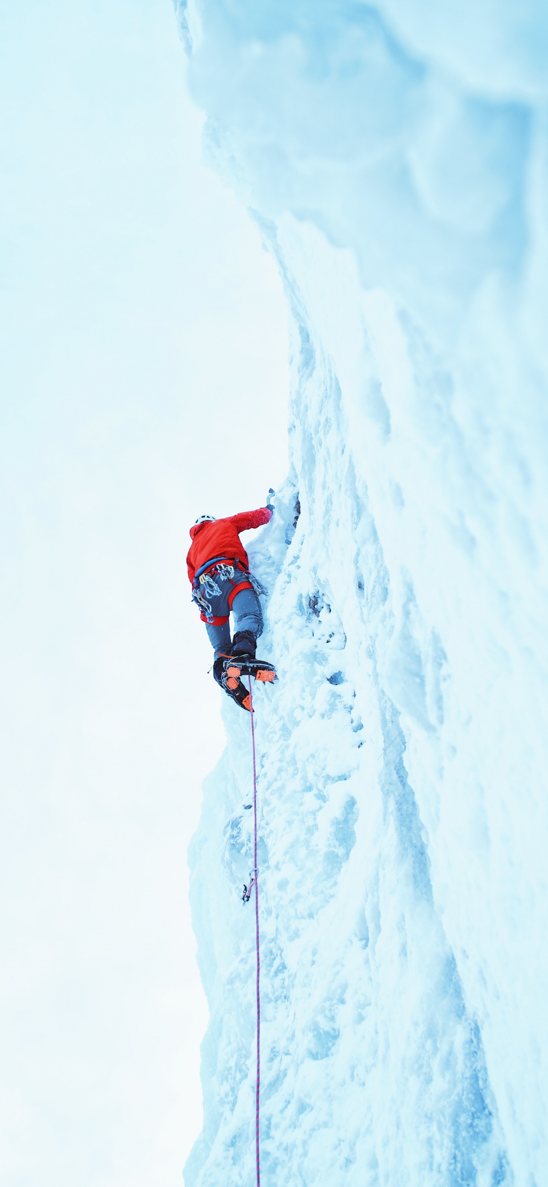 Person in Roter Jacke Und Blauer Hose Auf Schneebedeckten Bergen Tagsüber. Wallpaper in 1125x2436 Resolution