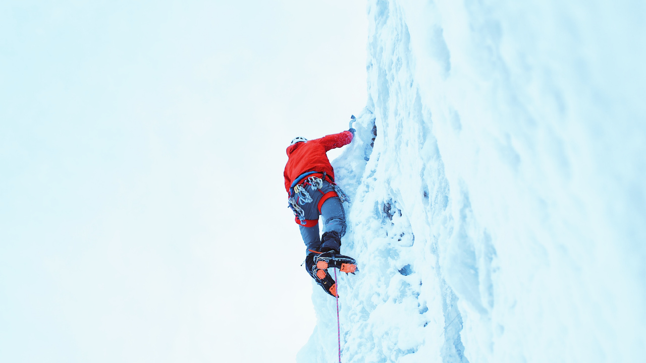 Persona en Chaqueta Roja y Pantalón Azul en la Montaña Cubierta de Nieve Durante el Día. Wallpaper in 1280x720 Resolution