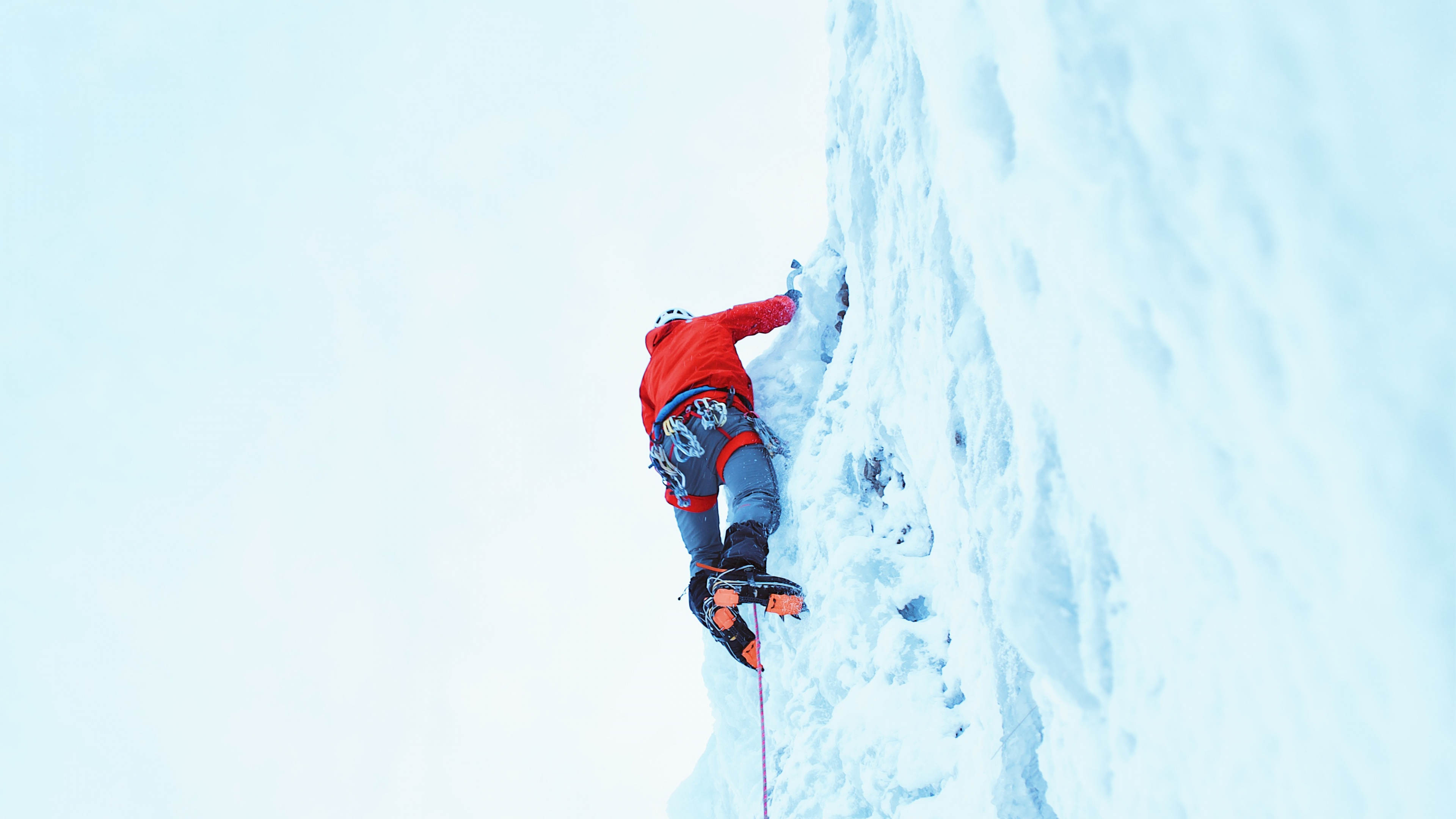 Persona en Chaqueta Roja y Pantalón Azul en la Montaña Cubierta de Nieve Durante el Día. Wallpaper in 3840x2160 Resolution