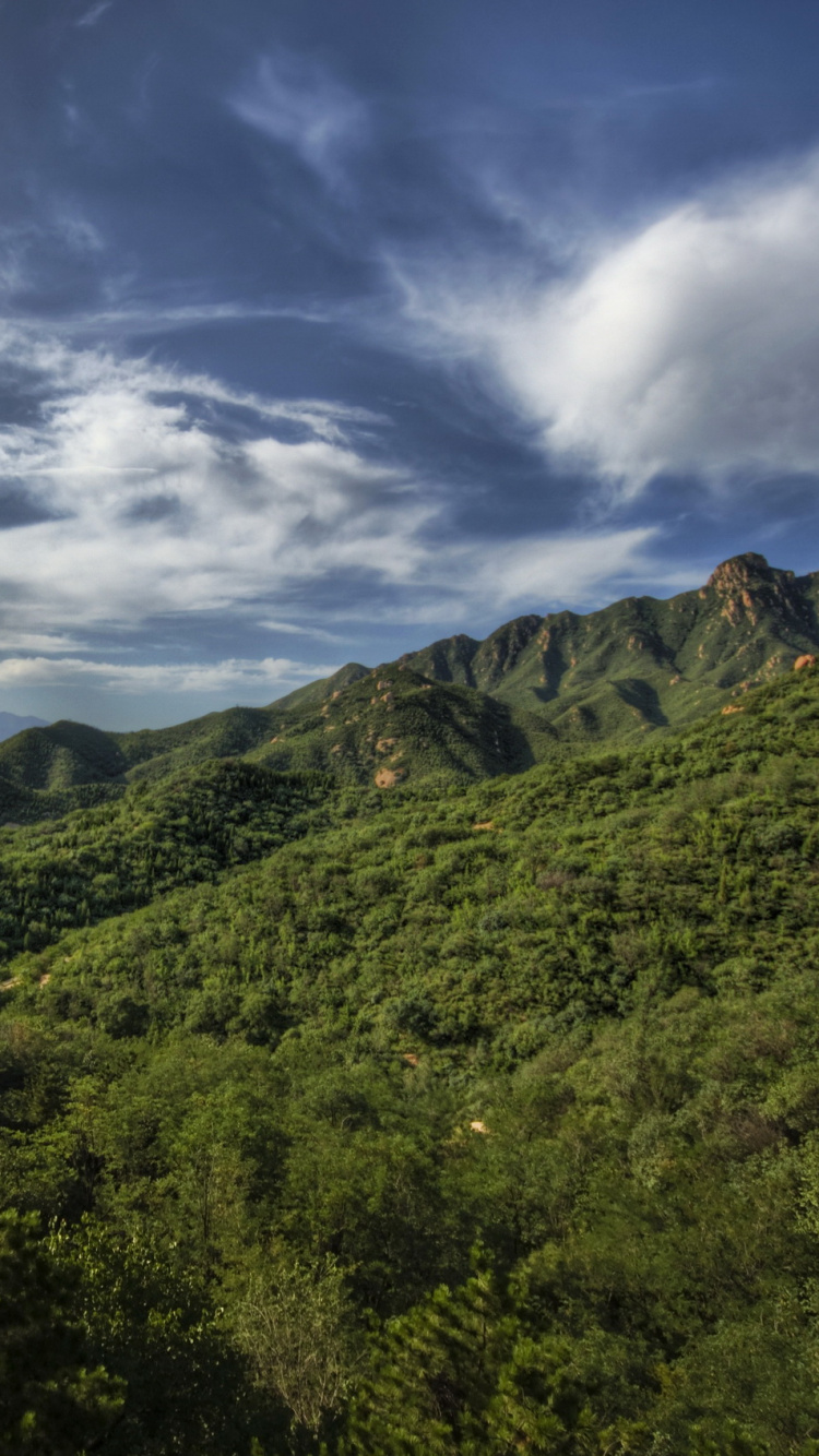 Grüne Bäume Auf Dem Berg Unter Weißen Wolken Und Blauem Himmel Tagsüber. Wallpaper in 750x1334 Resolution
