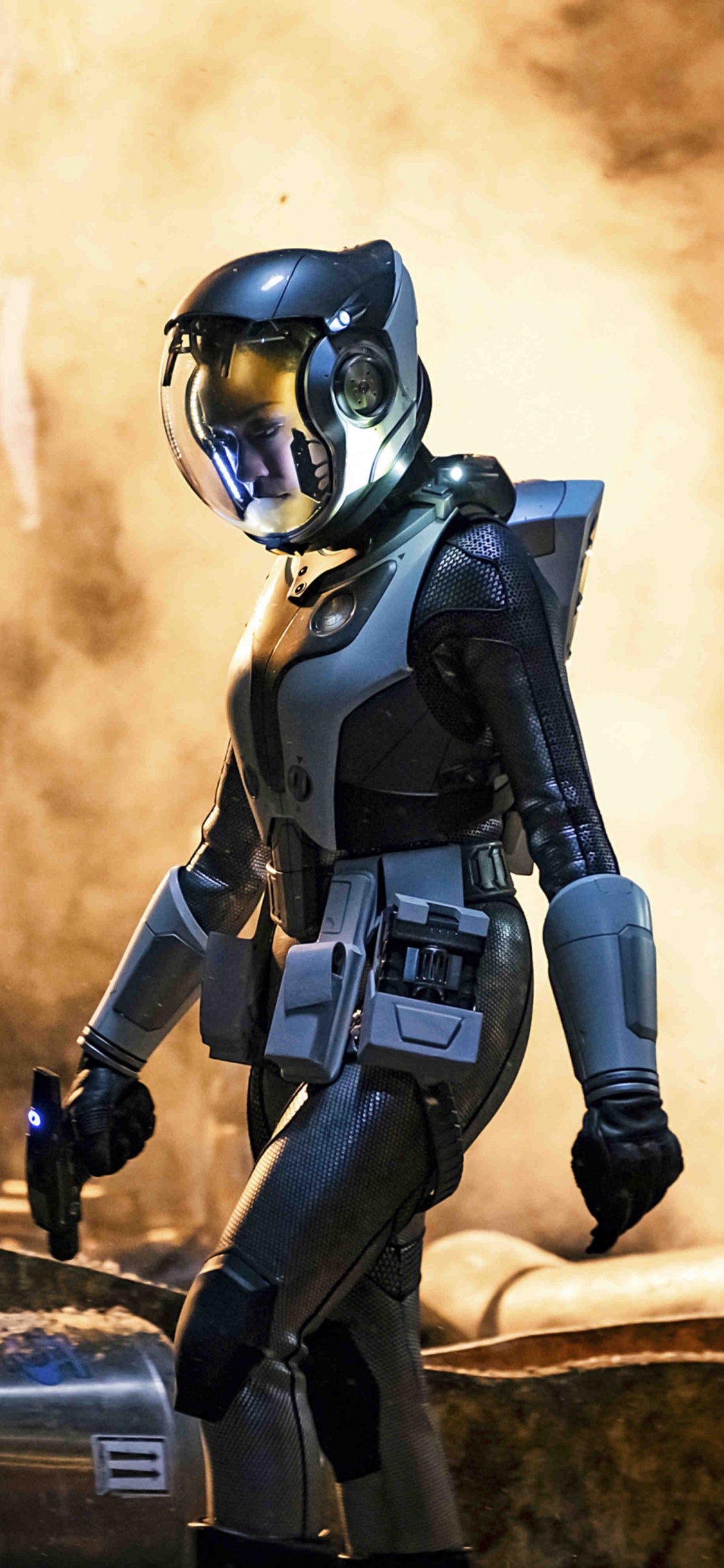 Mujer en Traje Negro y Gris Con Rifle Negro. Wallpaper in 1125x2436 Resolution