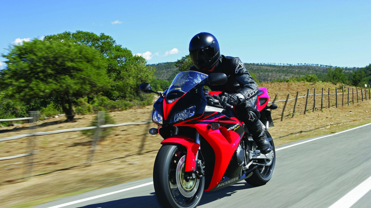 Homme en Costume de Moto Noir et Rouge à Cheval Sur un Vélo de Sport Rouge Sur la Route Pendant la Journée. Wallpaper in 1280x720 Resolution