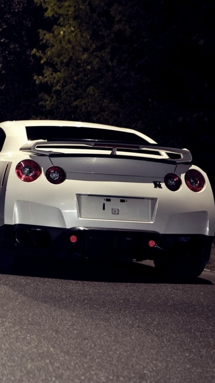 Weißer Und Schwarzer Porsche 911 Unterwegs Während Der Nacht. Wallpaper in 720x1280 Resolution