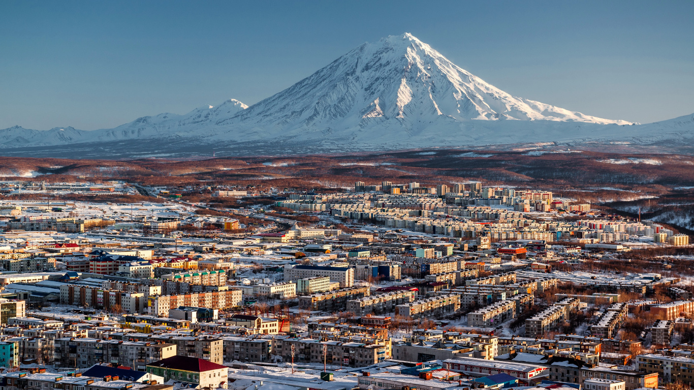 Aerial View of City Buildings Near Snow Covered Mountain During Daytime. Wallpaper in 1366x768 Resolution