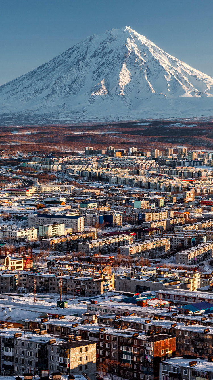 Aerial View of City Buildings Near Snow Covered Mountain During Daytime. Wallpaper in 750x1334 Resolution