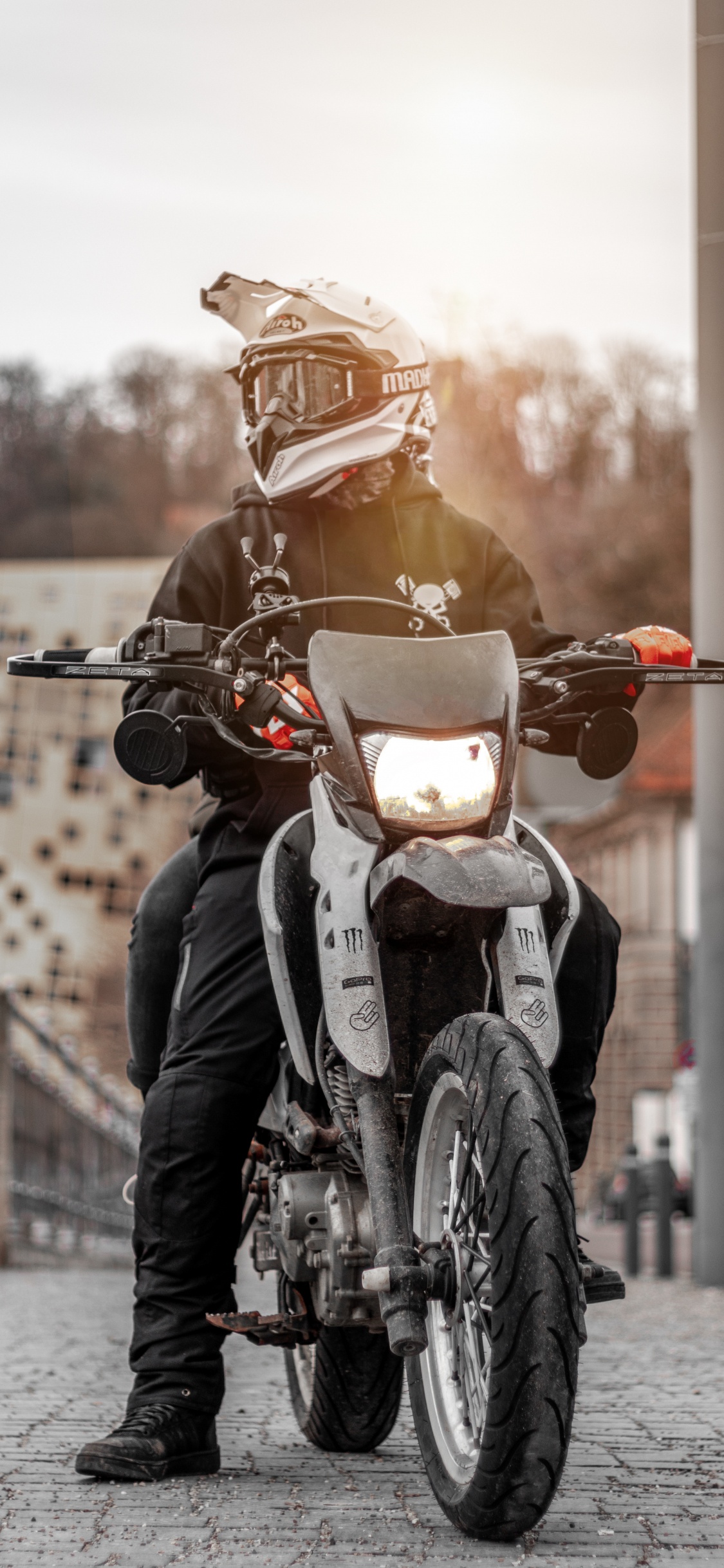 Mann in Schwarzer Lederjacke, Der Tagsüber Motorrad Fährt. Wallpaper in 1125x2436 Resolution