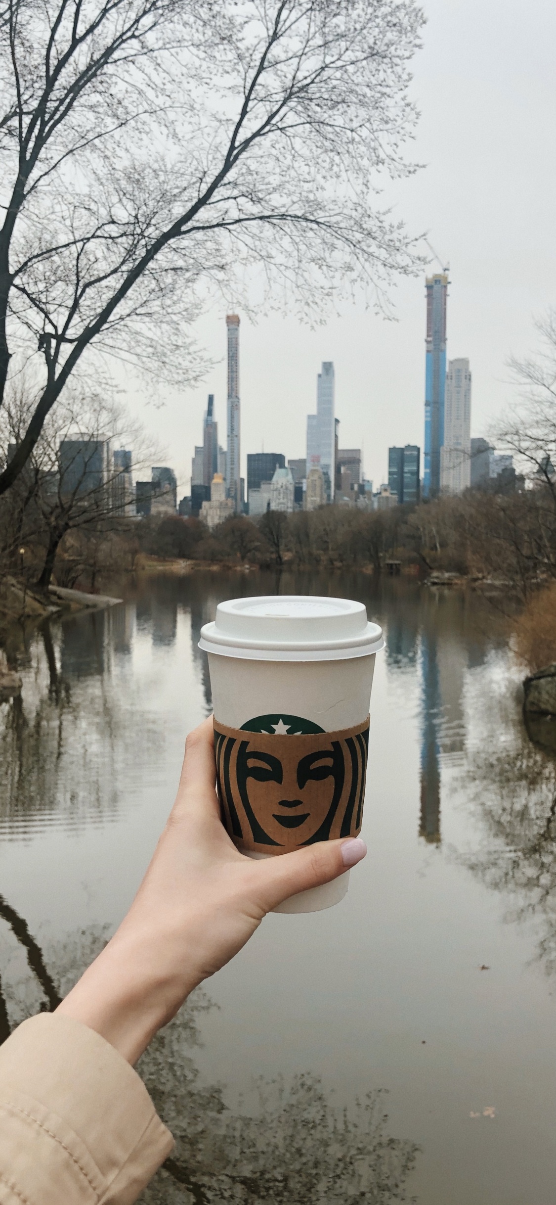Person Mit Weißem Und Braunem Einwegbecher. Wallpaper in 1125x2436 Resolution