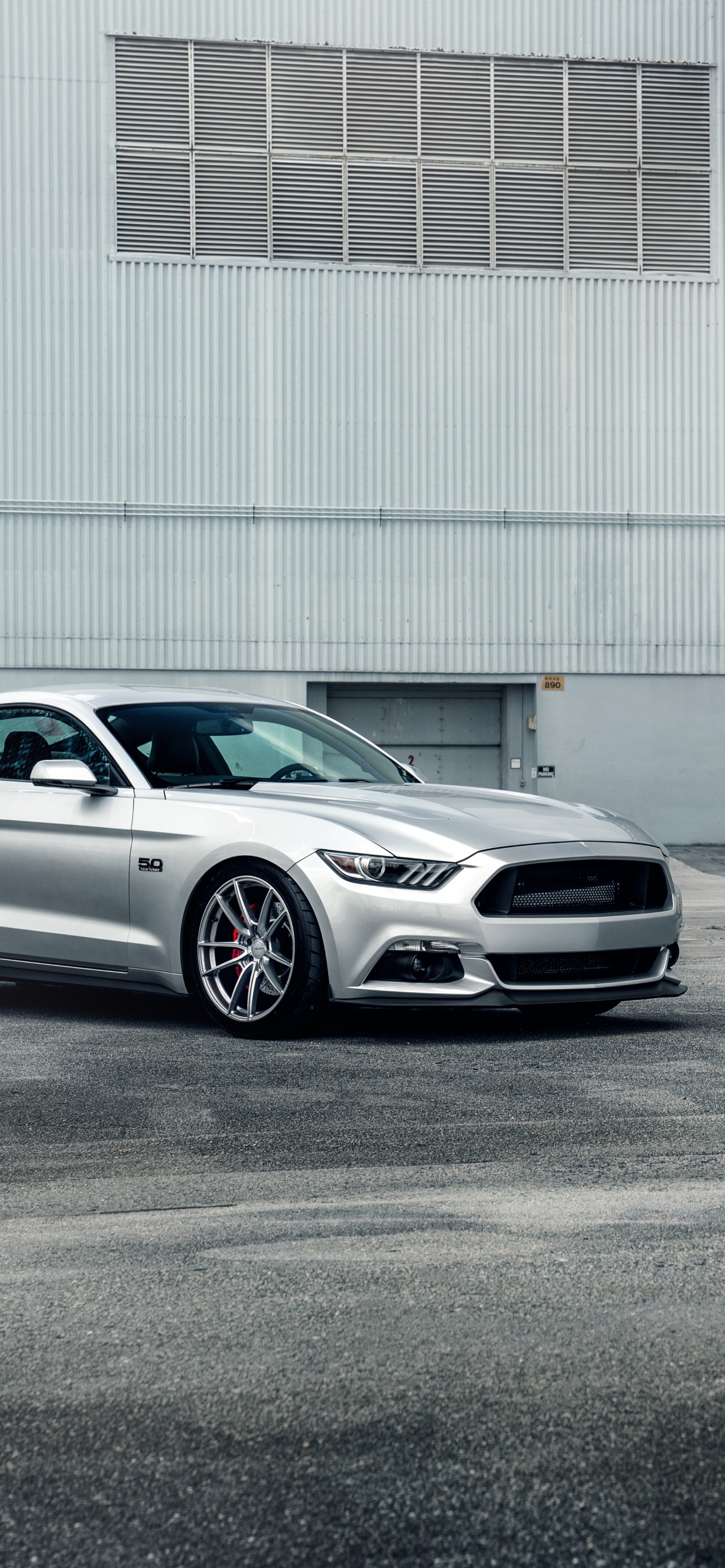 Sedán Blanco Estacionado Cerca Del Edificio Blanco. Wallpaper in 1242x2688 Resolution