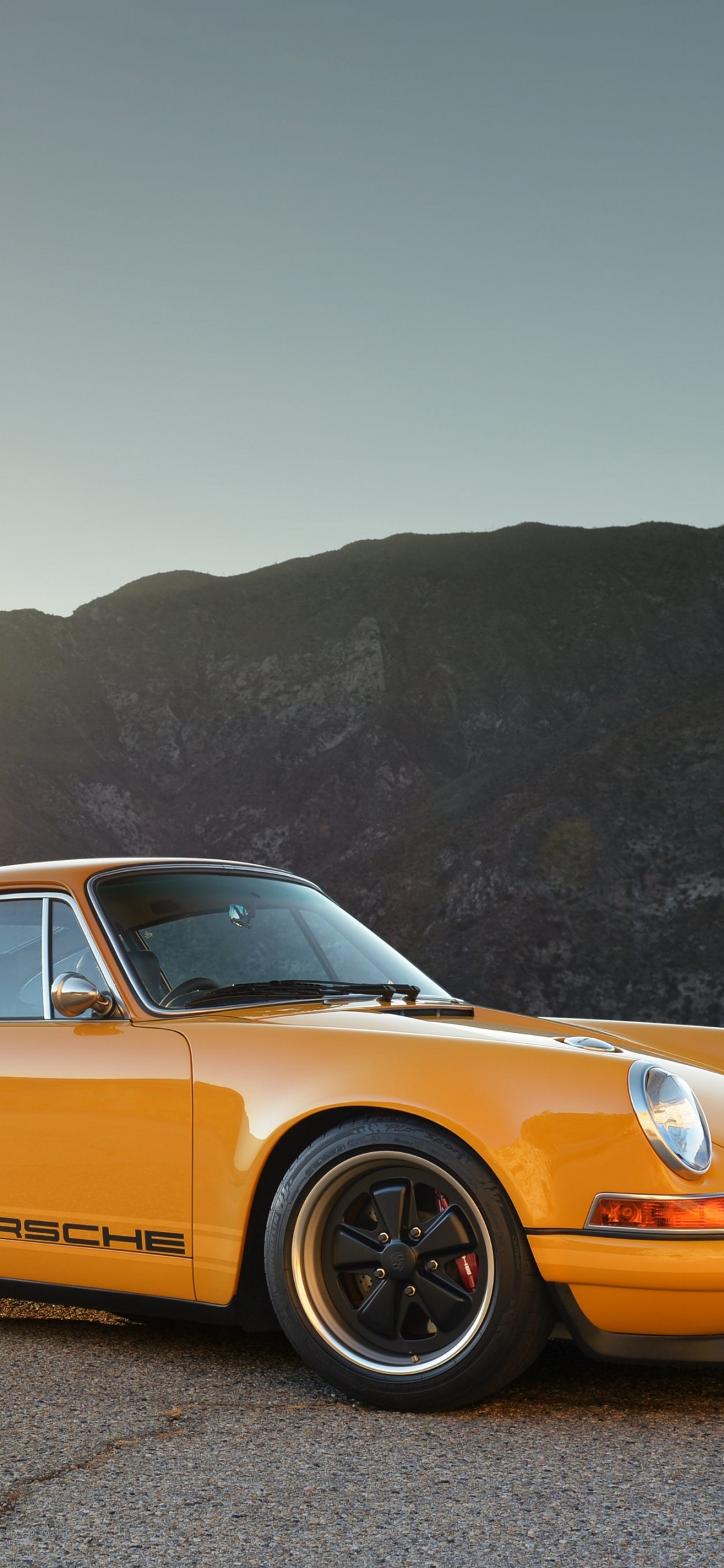 Yellow Porsche 911 on Brown Dirt Road During Daytime. Wallpaper in 1125x2436 Resolution