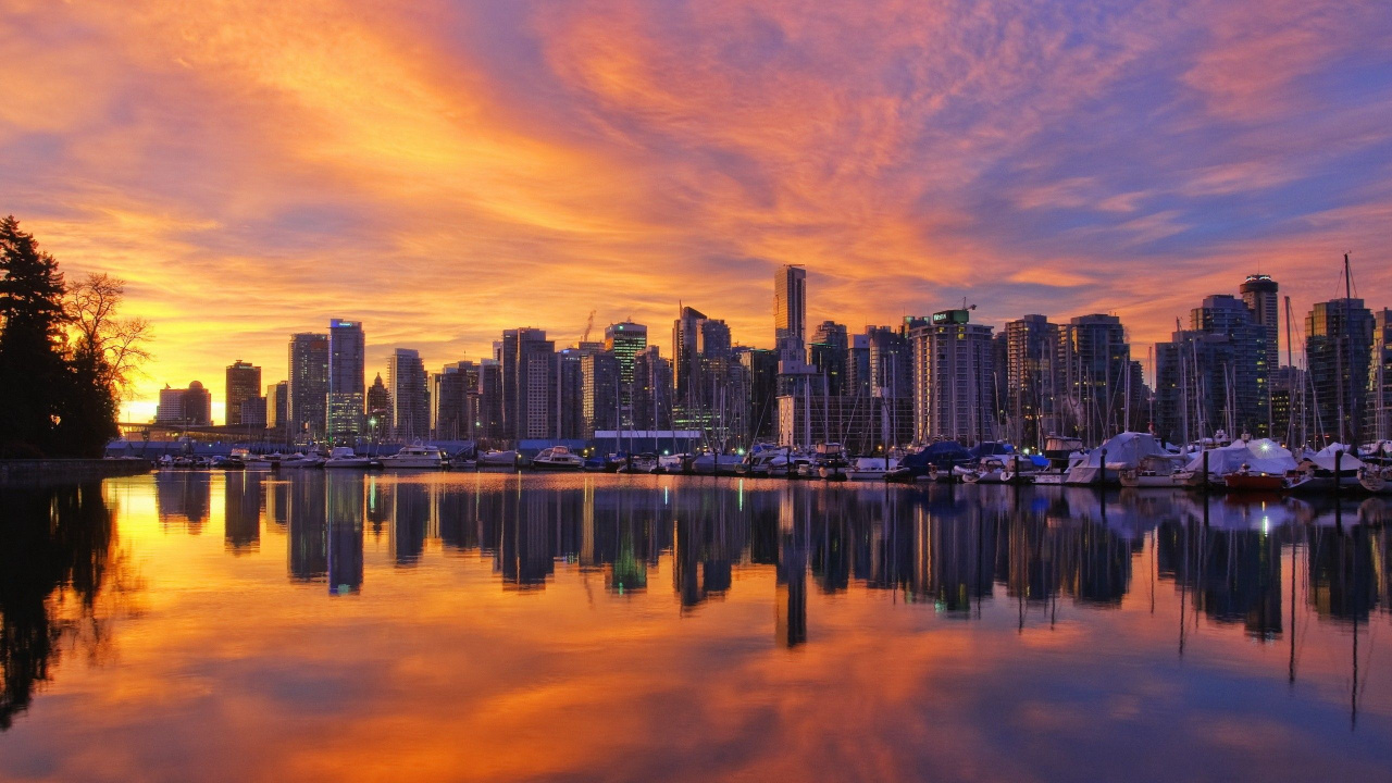 City Skyline Across Body of Water During Sunset. Wallpaper in 1280x720 Resolution