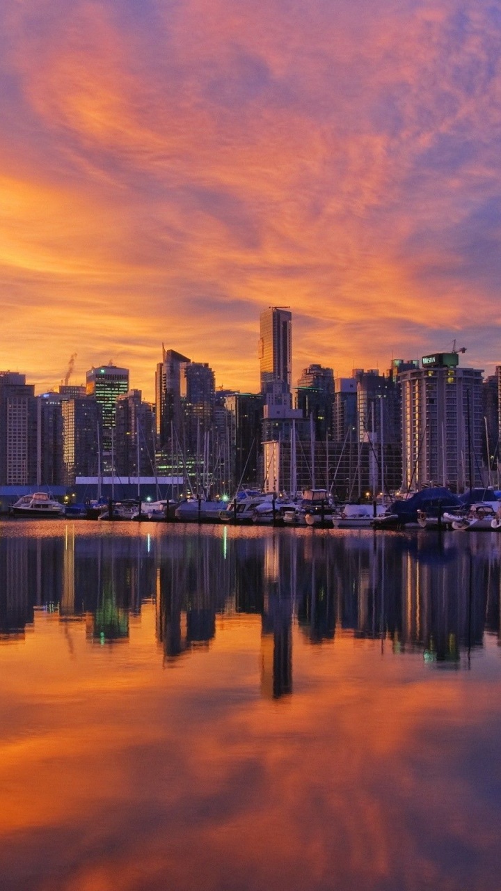 City Skyline Across Body of Water During Sunset. Wallpaper in 720x1280 Resolution