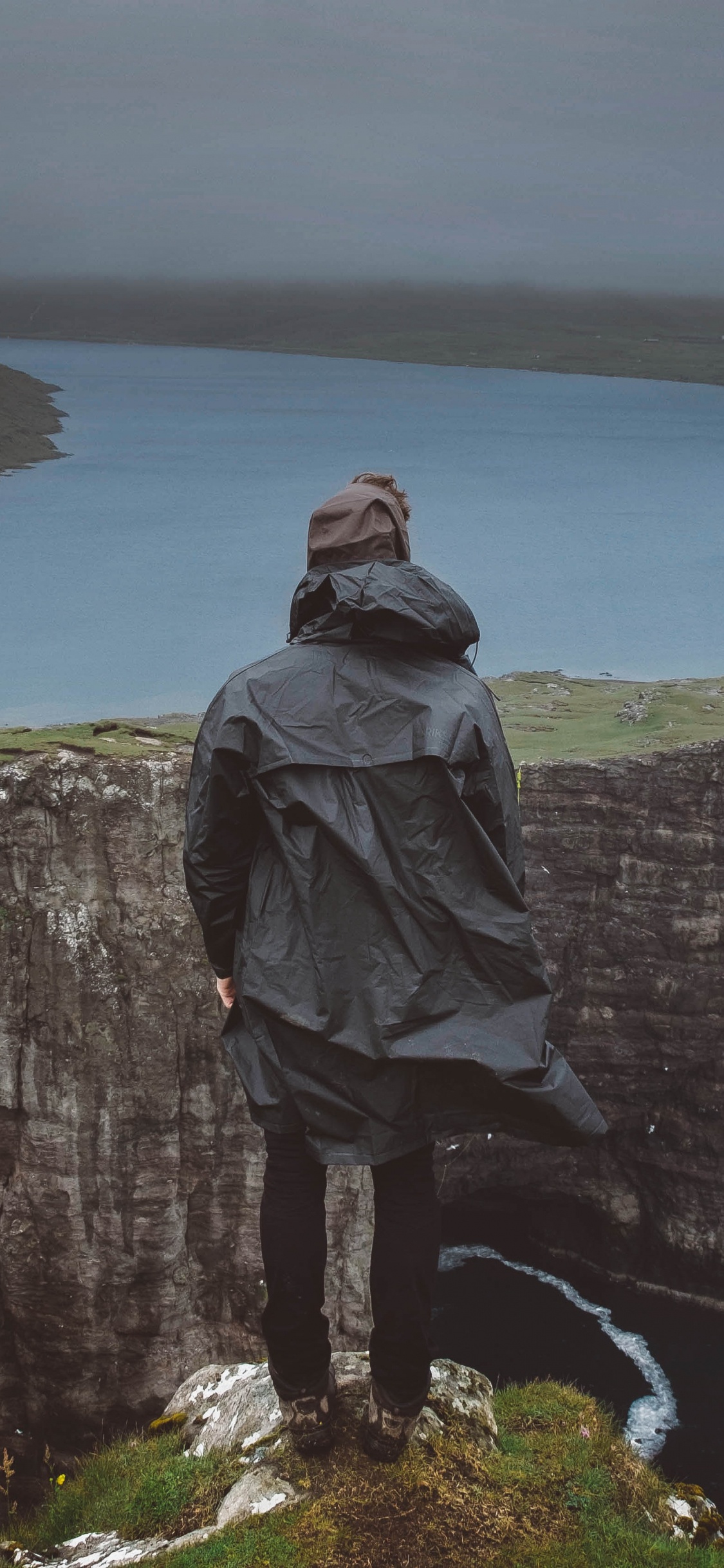 Homme en Sweat à Capuche Gris Debout Sur la Falaise Pendant la Journée. Wallpaper in 1125x2436 Resolution