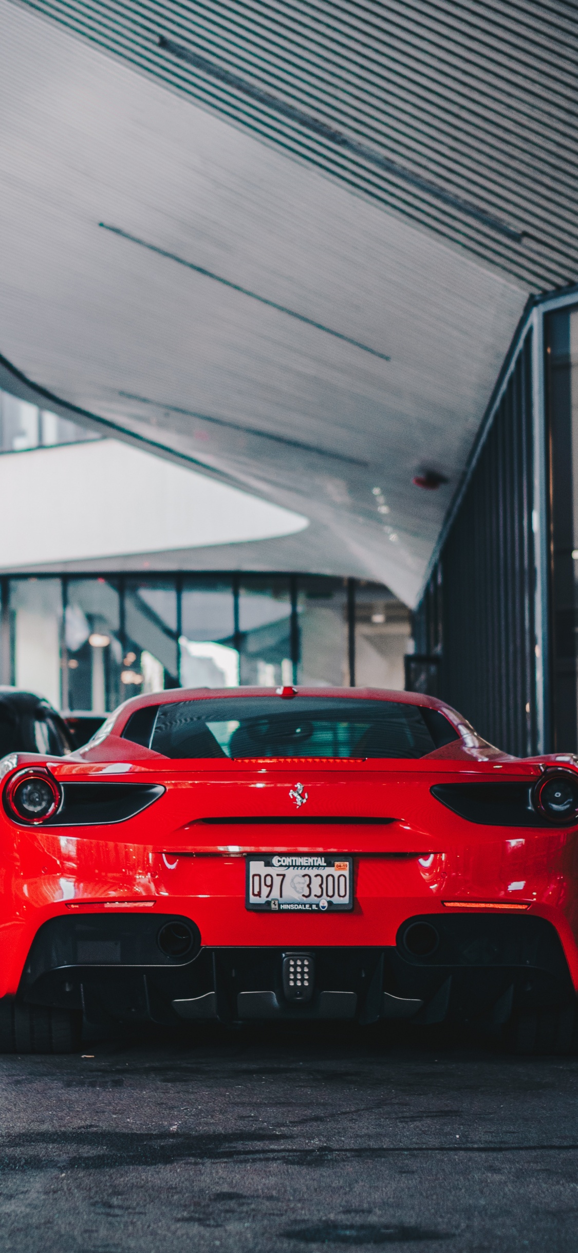 Red Ferrari Car Parked Near Building. Wallpaper in 1125x2436 Resolution