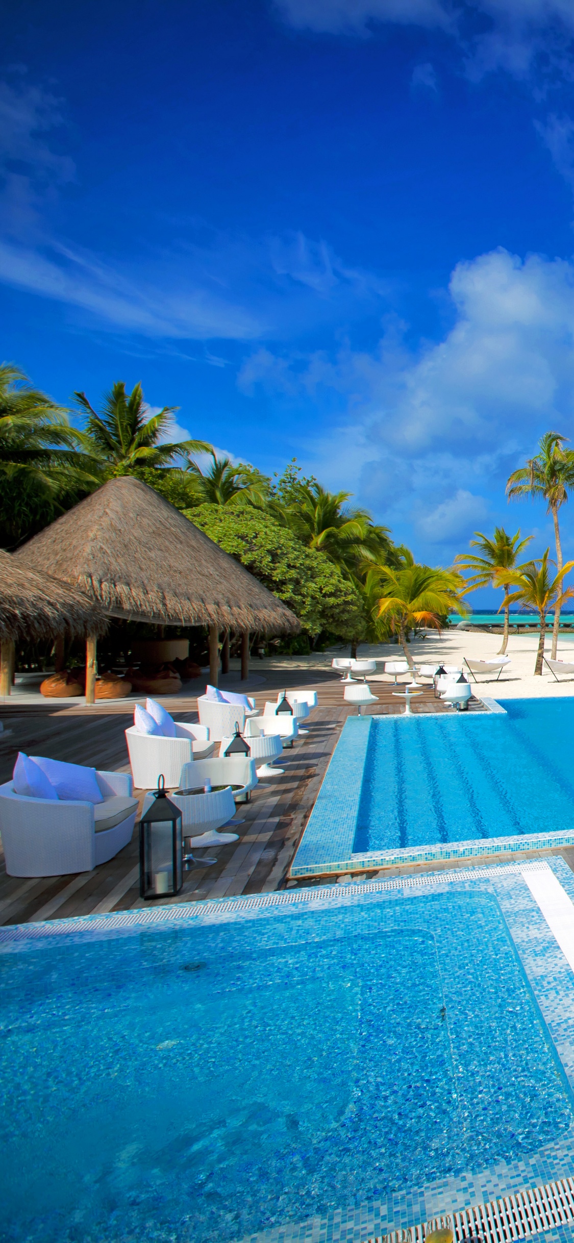 Brown Wooden Lounge Chairs on Blue Swimming Pool During Daytime. Wallpaper in 1125x2436 Resolution