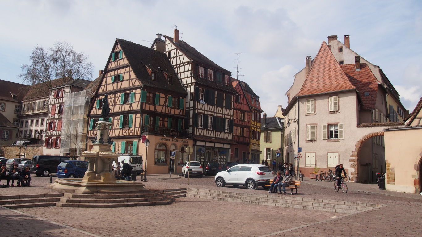 Voitures Garées à Côté D'un Bâtiment en Béton Brun Pendant la Journée. Wallpaper in 1366x768 Resolution