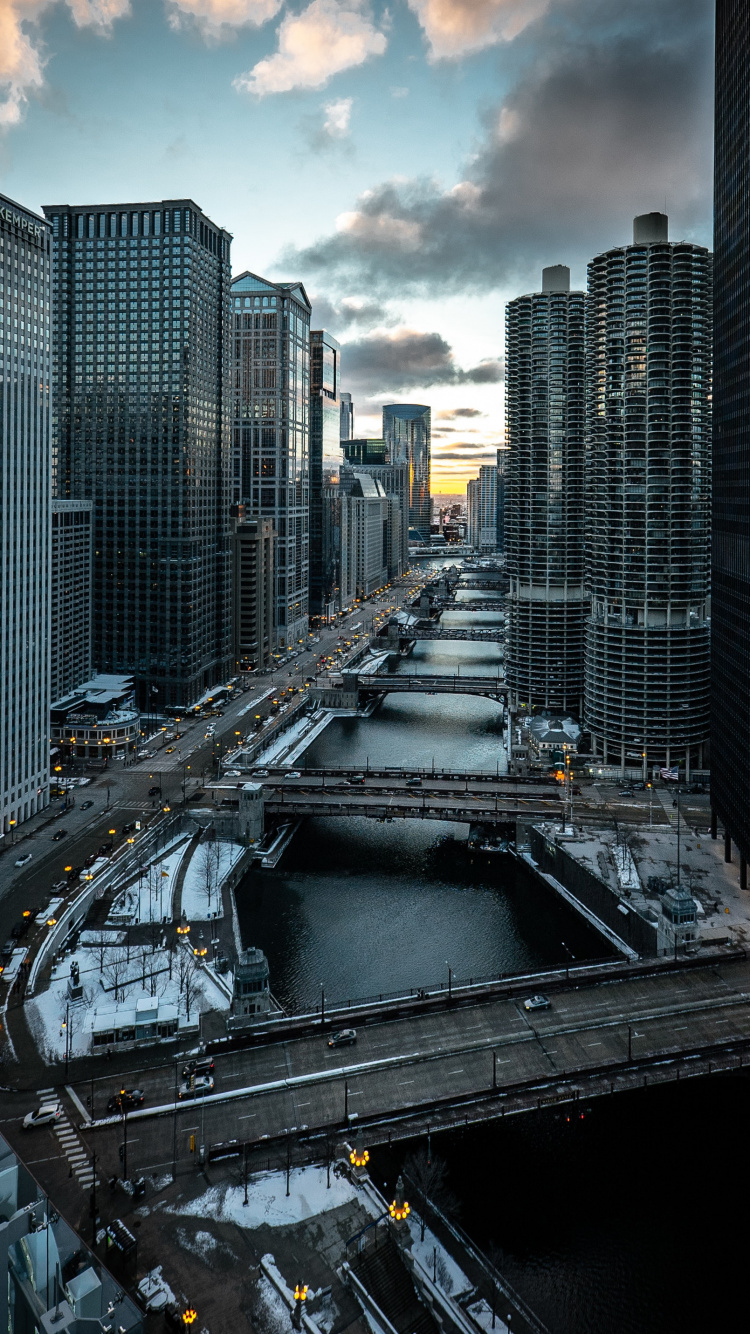 Voitures Sur Route Entre Les Immeubles de Grande Hauteur Pendant la Journée. Wallpaper in 750x1334 Resolution