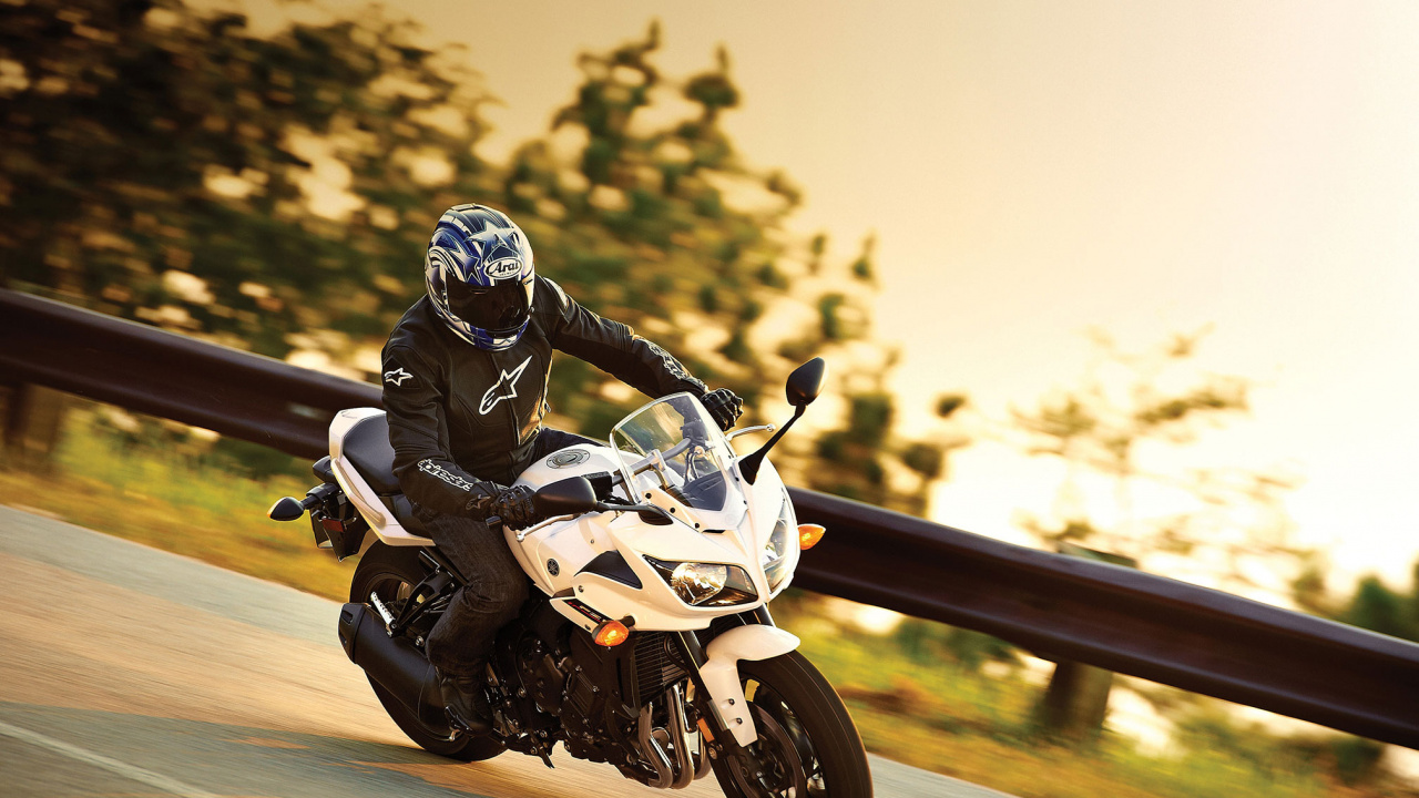 Mann im Schwarzen Und Weißen Motorradanzug, Der Weißes Sportrad Fährt. Wallpaper in 1280x720 Resolution