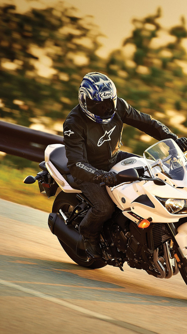 Man in Black and White Motorcycle Suit Riding White Sports Bike. Wallpaper in 750x1334 Resolution