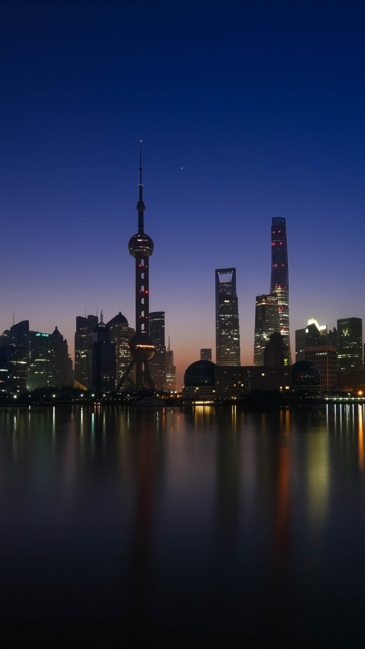 City Skyline Across Body of Water During Night Time. Wallpaper in 720x1280 Resolution
