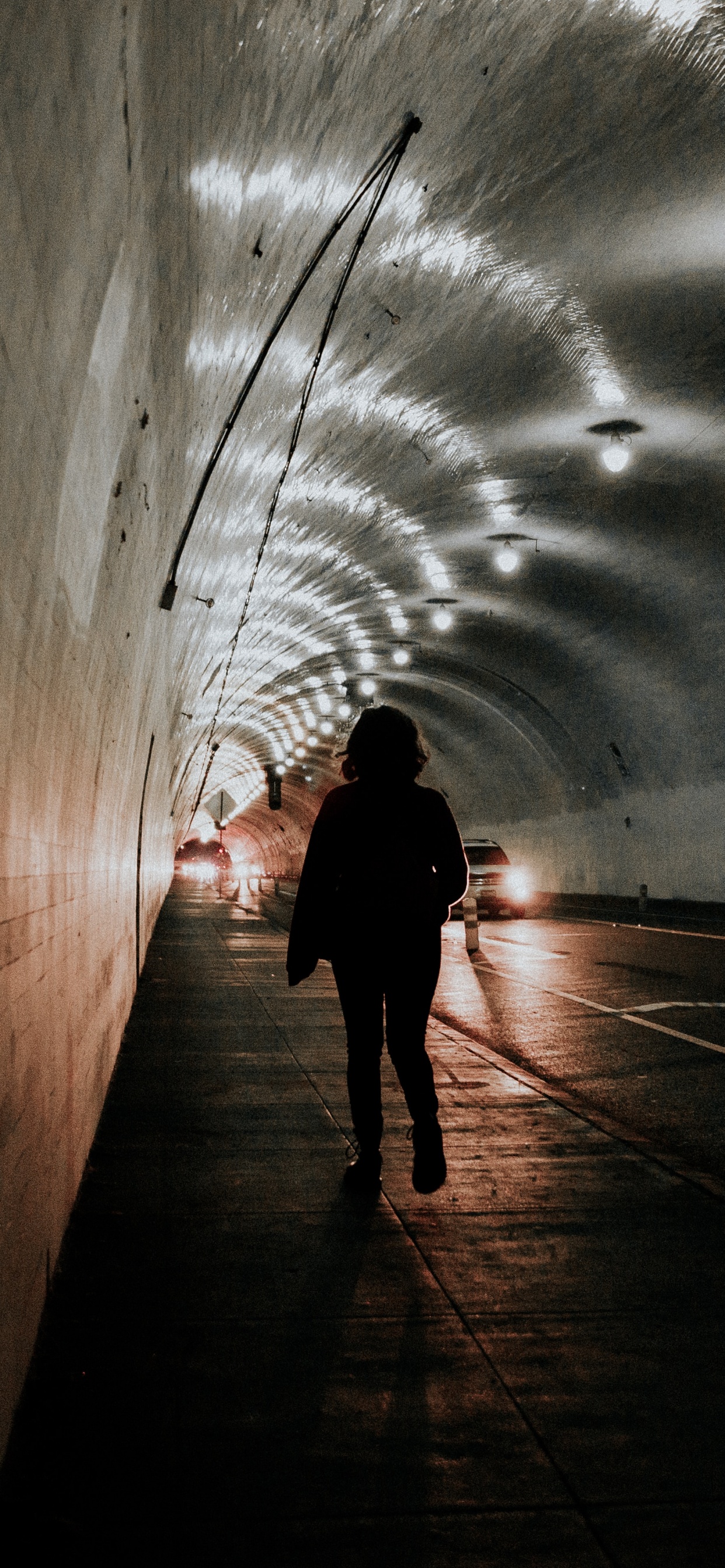 Silueta de Persona Caminando en el Túnel. Wallpaper in 1242x2688 Resolution