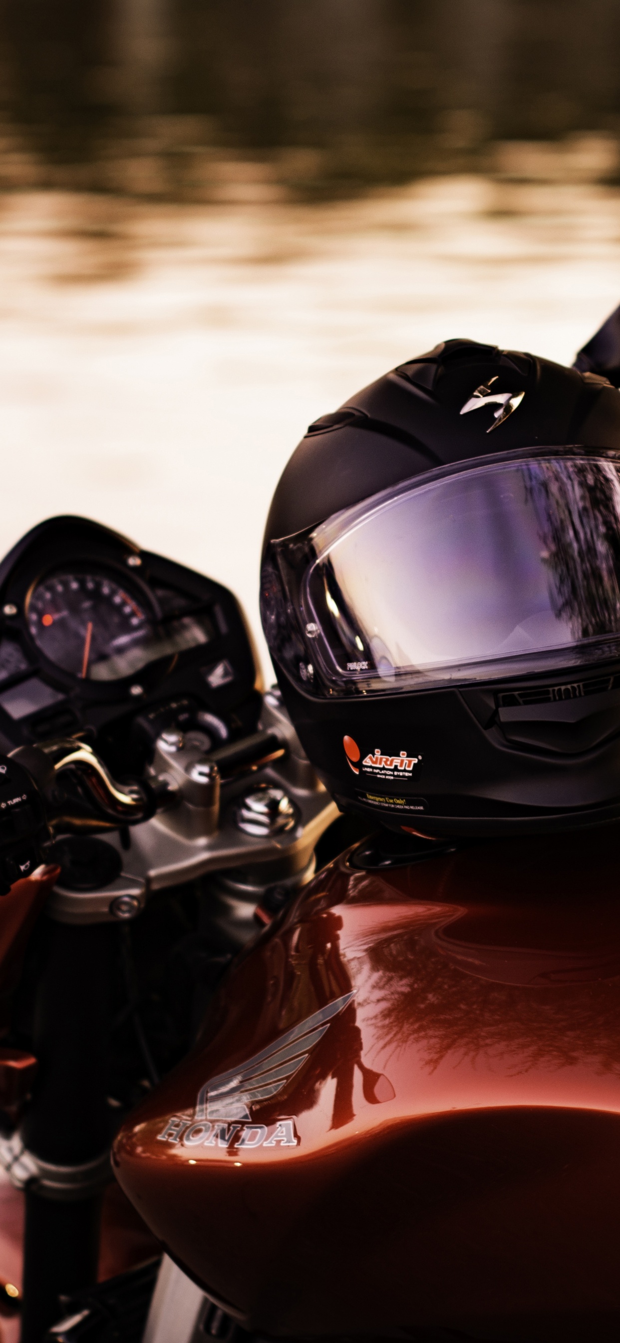 Casque de Moto Noir et Rouge Sur Moto Rouge. Wallpaper in 1242x2688 Resolution