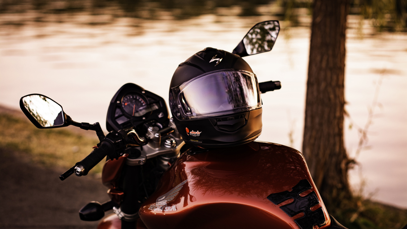 Schwarz-roter Motorradhelm Auf Rotem Motorrad. Wallpaper in 1366x768 Resolution